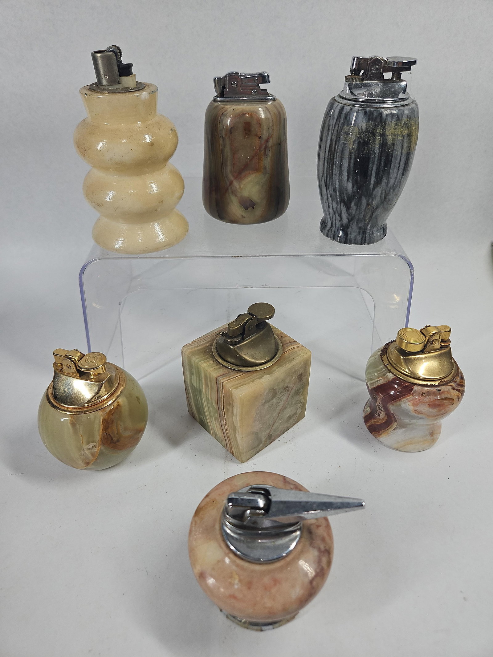 Vtg Natural Stone & Onyx Table Lighters: An assortment of table lighters featuring carved natural stone bases in various forms and mineral varieties, including banded onyx and veined marble. The collection includes a tiered lobed cream