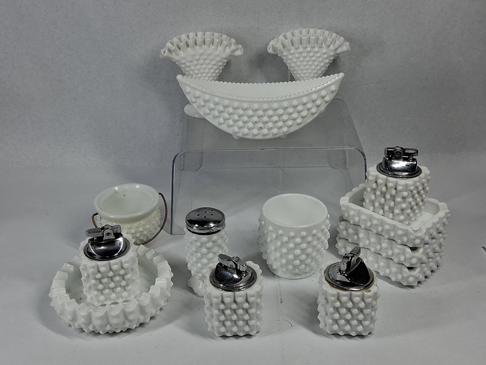 14 Fenton White Hobnail Milk Glass: A collection of fourteen white milk glass decorative and utility items produced in the hobnail pattern, featuring rows of raised rounded projections across the exterior surfaces. The assortment