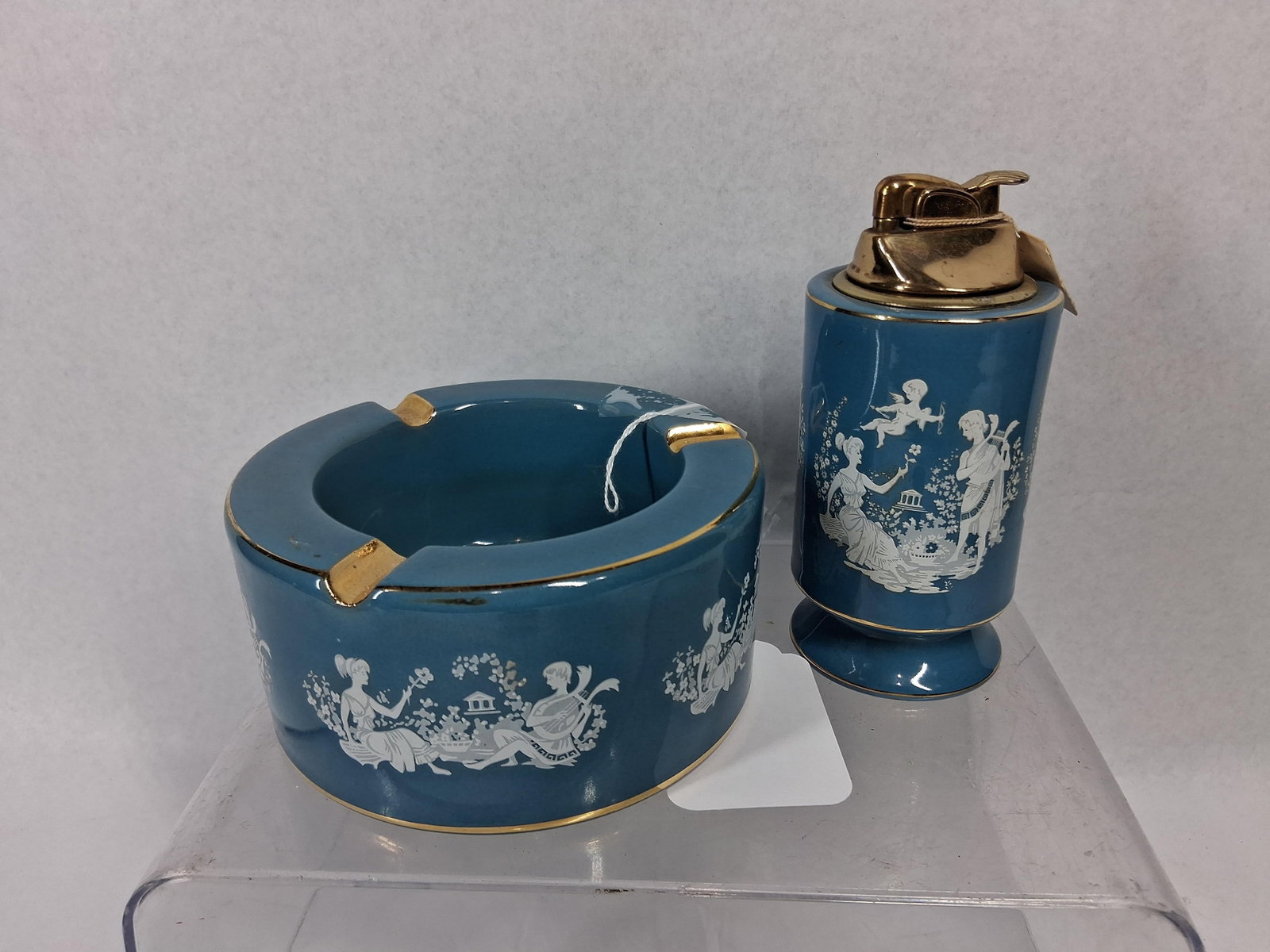 Pair Italian Florentine Lighter/Ashtray: An Italian two-piece smoking set consisting of a table lighter and a matching circular ashtray. Each piece is constructed of earthenware finished in a vibrant teal blue glossy glaze. The exterior