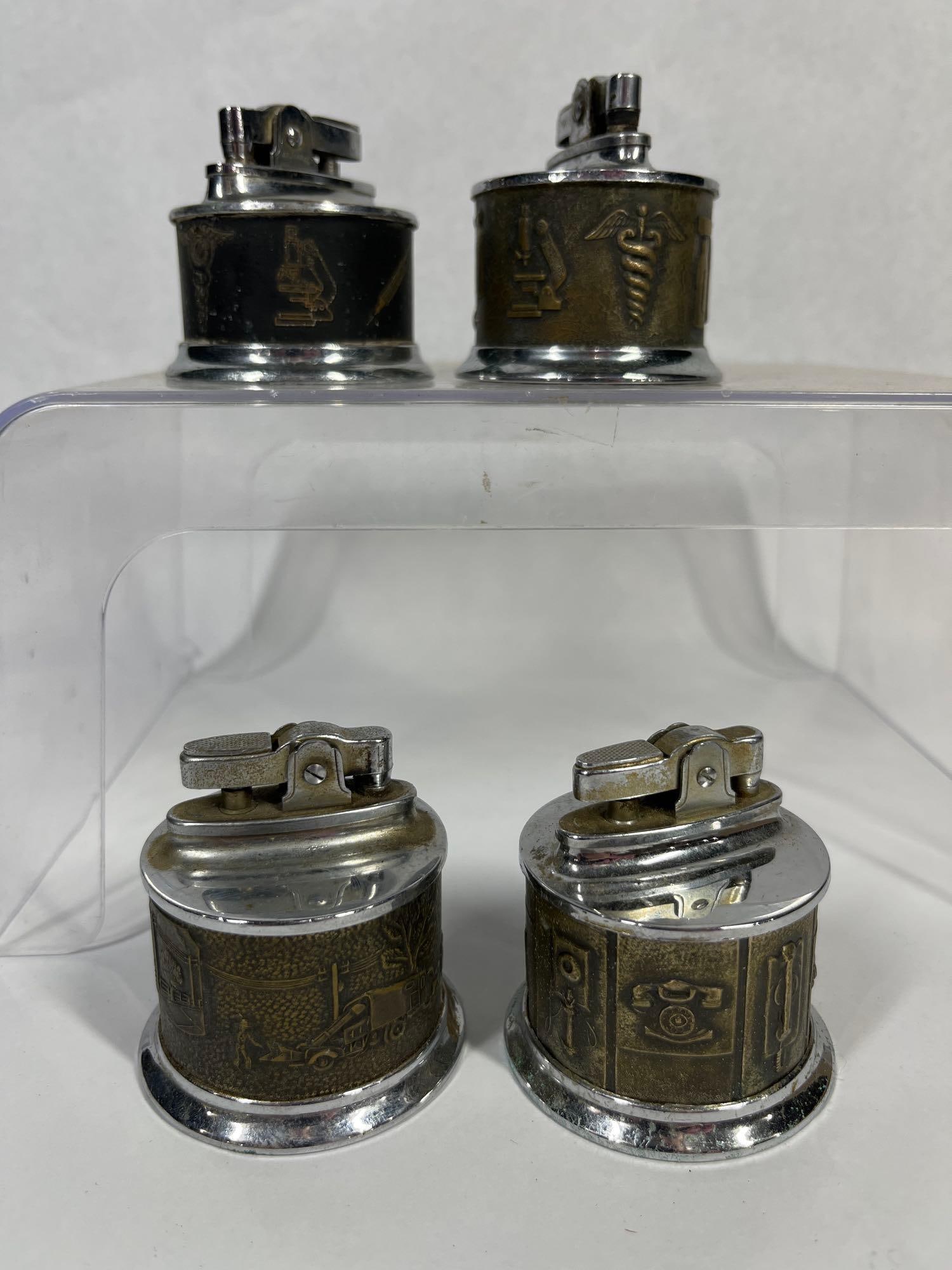 Vtg Idealine Japanese Table Lighter Set: A collection of vintage cylindrical table lighters of Japanese manufacture. The set consists of four metal lighters, each featuring a polished chrome-finished top and base surrounding a decorative cen