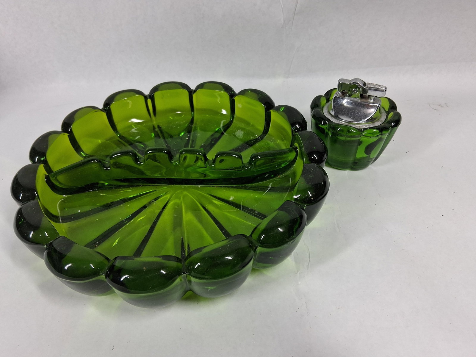Green Pressed Glass Ashtray & Lighter: This two-piece smoking set, featuring a Japanese metal lighter insert, is constructed from heavy pressed glass in a deep emerald green color. The set consists of a large circular ashtray and a matchin