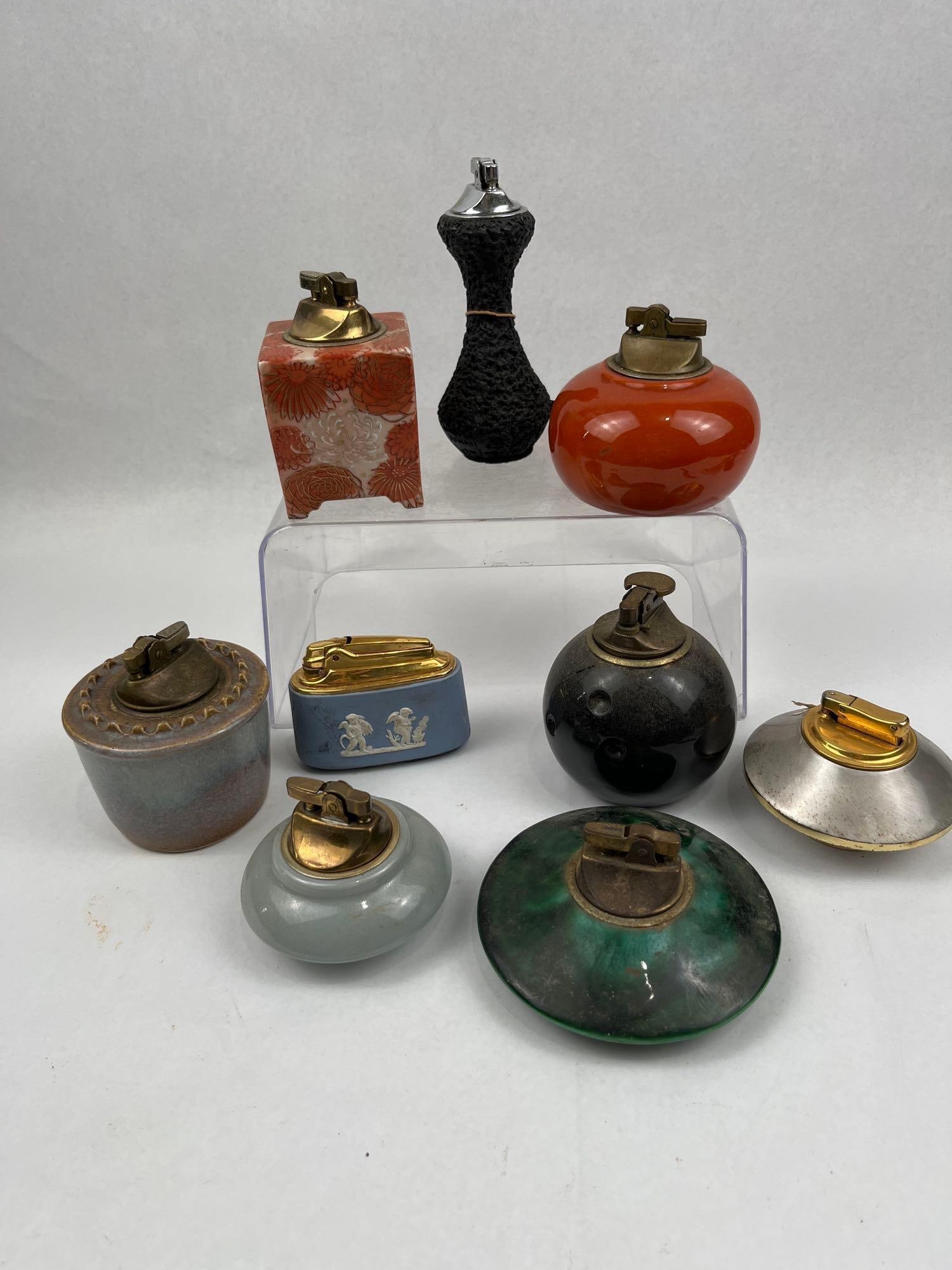 Vtg Wedgwood, Colibri & Kutani Lighters: A collection of vintage table lighters showcasing a variety of mid-century materials and makers. The group includes a blue English jasperware table lighter decorated with white classical reliefs and
