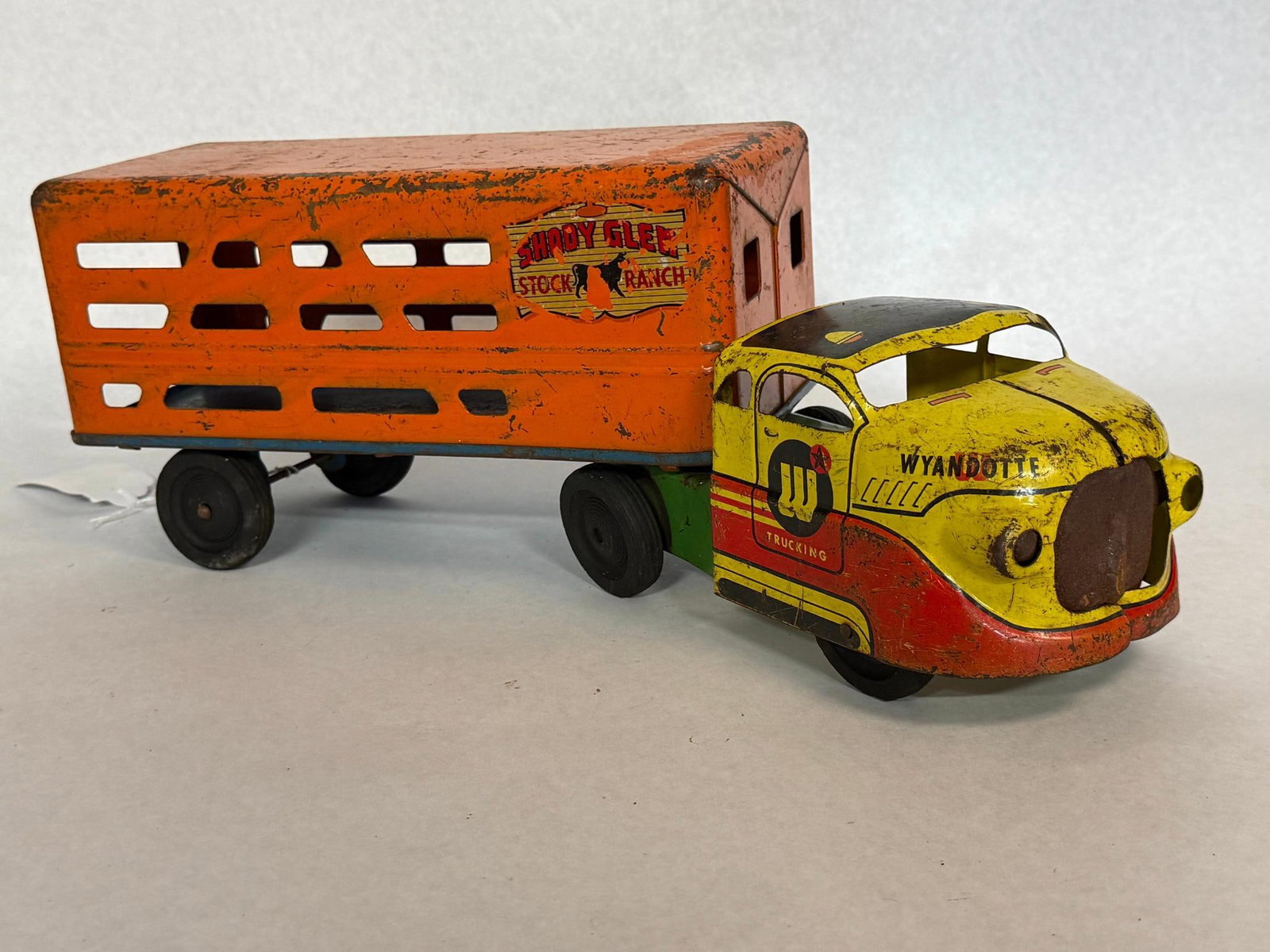 Wyandotte Shady Glen Truck & Trailer: A mid-20th-century pressed steel toy tractor-trailer combination produced by Wyandotte. Each cab door features a circular logo containing a large letter W with a small red star above a red band