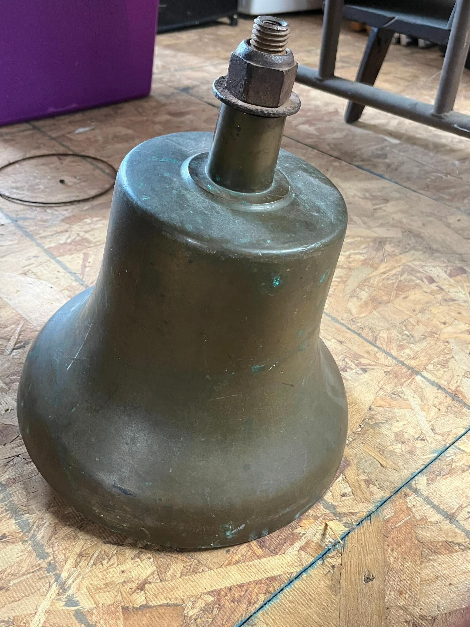 1925 Patent Industrial Cast Bronze Bell: A large cast bronze or brass bell featuring a heavy internal iron clapper and a top crown mounting assembly. The clapper arm is marked with cast-in text reading PATD APR 14 1925. Dimensions: 14 in. H.