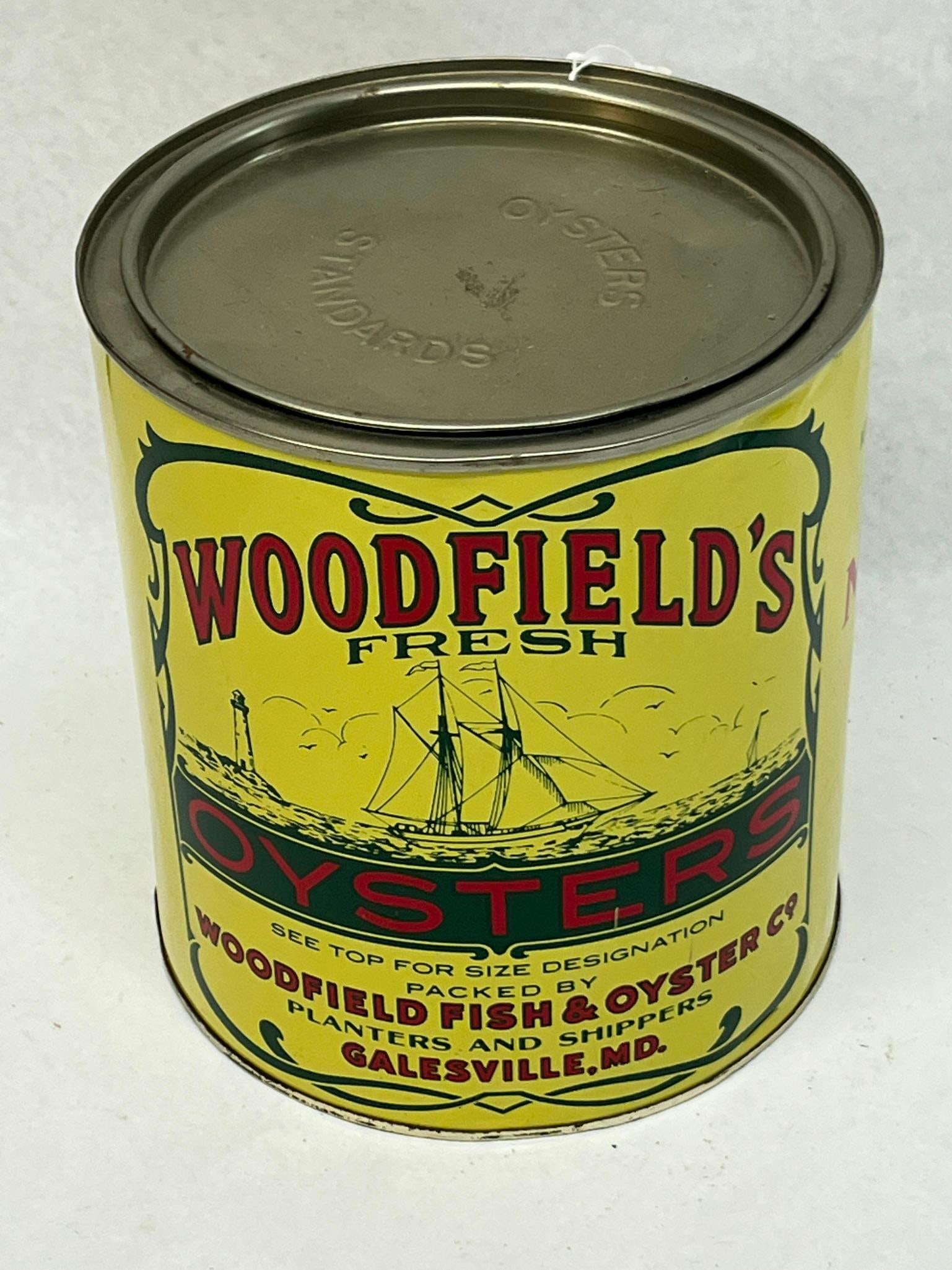 Woodfield Fish & Oyster Co Maryland Tin: A American one-gallon lithographed tin produced for the Woodfield Fish and Oyster Co. The primary face is printed in red and black text reading Woodfield's Fresh Oysters and Oysters. Below the
