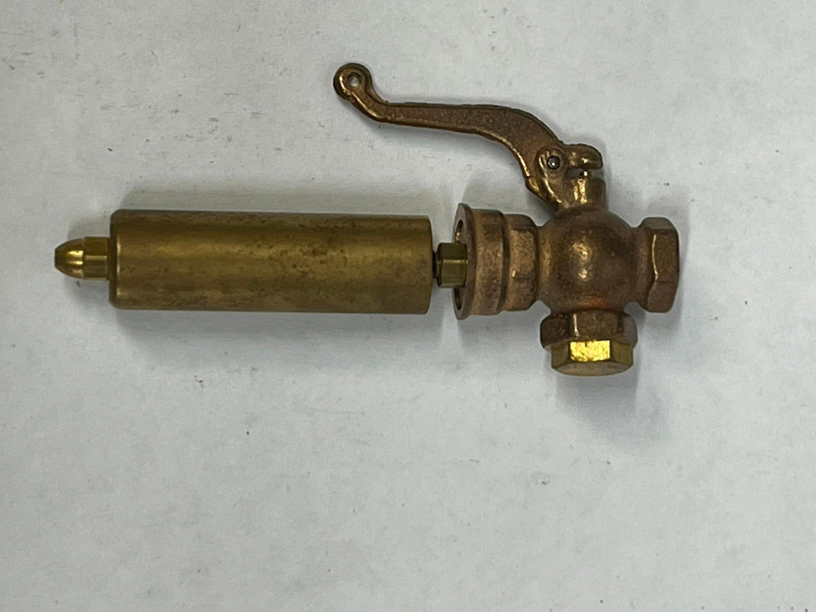 Antique Brass Single Bell Steam Whistle: This industrial whistle assembly is constructed from cast and turned brass and bronze components. Features a long, cylindrical turned brass single-chamber bell mounted to a T-shaped cast valve body.
