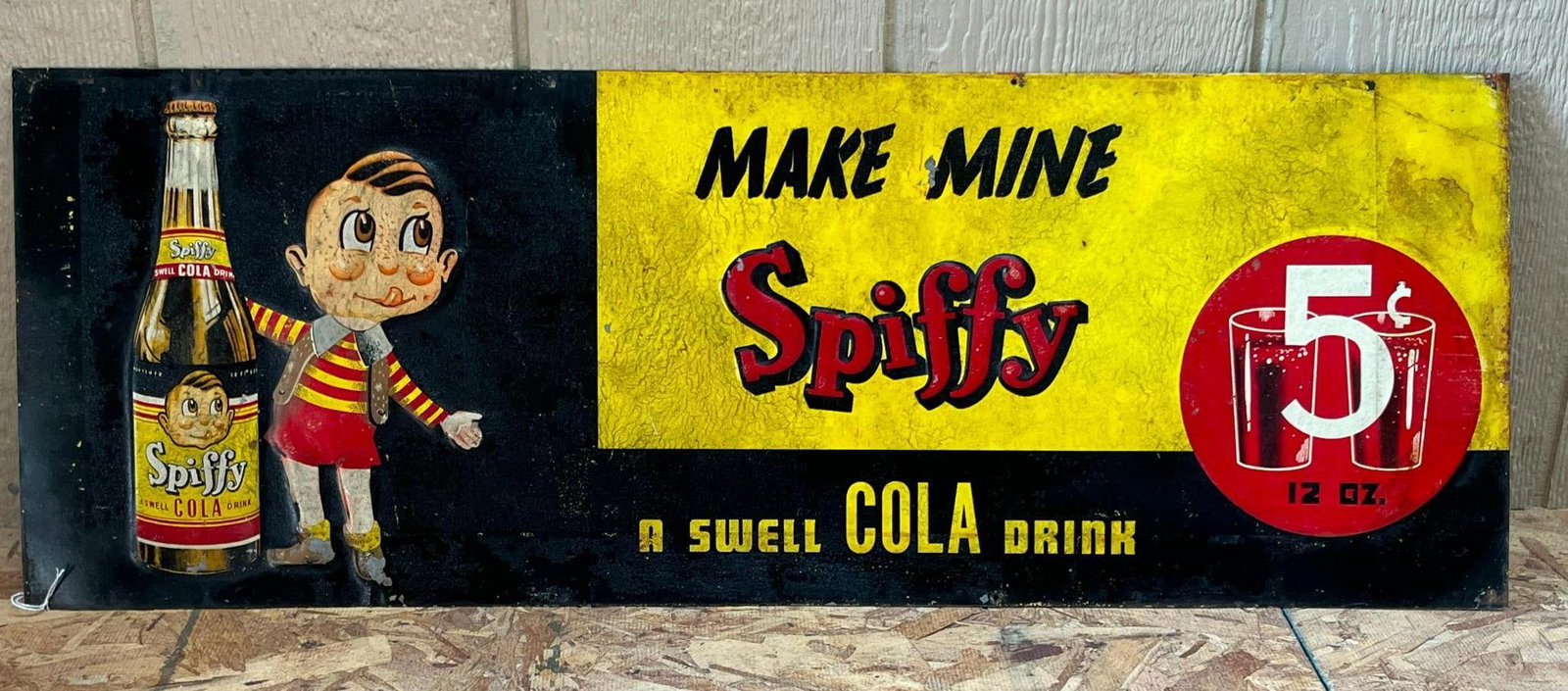 Spiffy Cola Embossed Tin Sign: A mid-20th-century rectangular advertising sign for Spiffy Cola, constructed from embossed sheet metal with a lithographed finish. The left section displays an embossed 12-ounce glass bottle of
