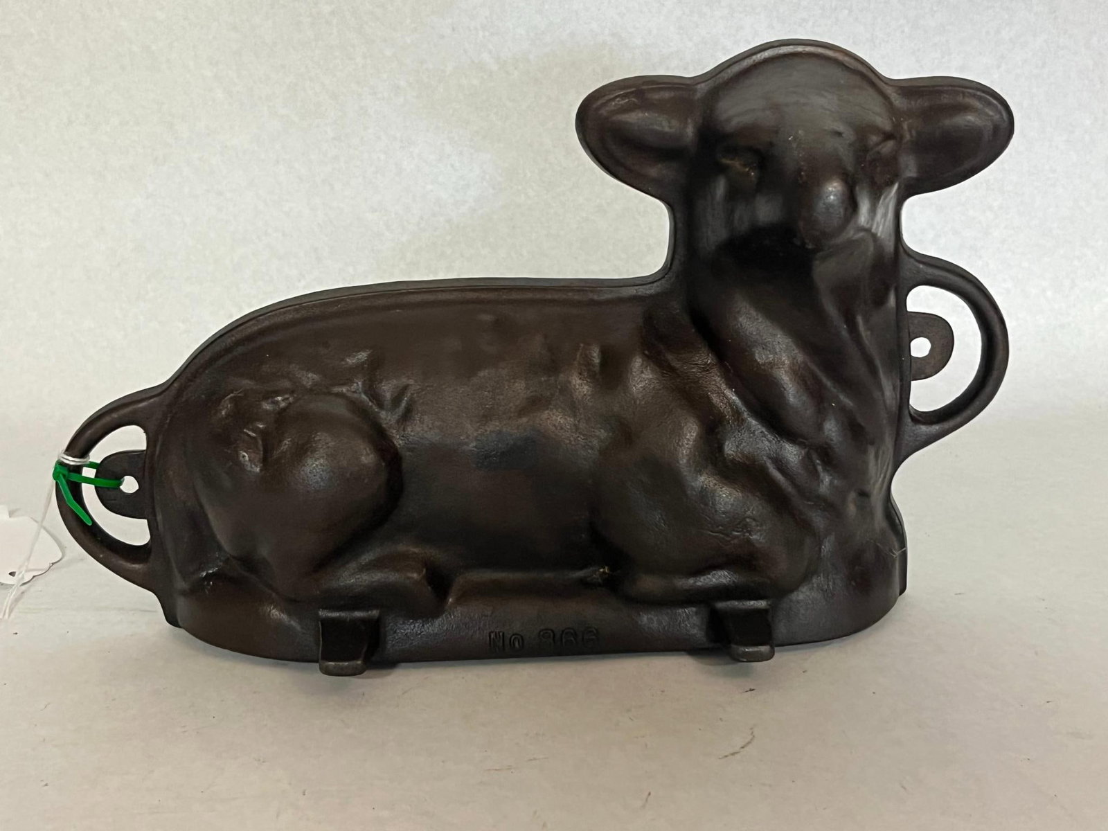 Cast Iron Lamb Cake Mold No. 866: A two-piece cast iron baking mold featuring a reclining lamb design. An impressed mark reading No 866 is visible on the base of the front piece. The cast iron has a dark, seasoned patina.