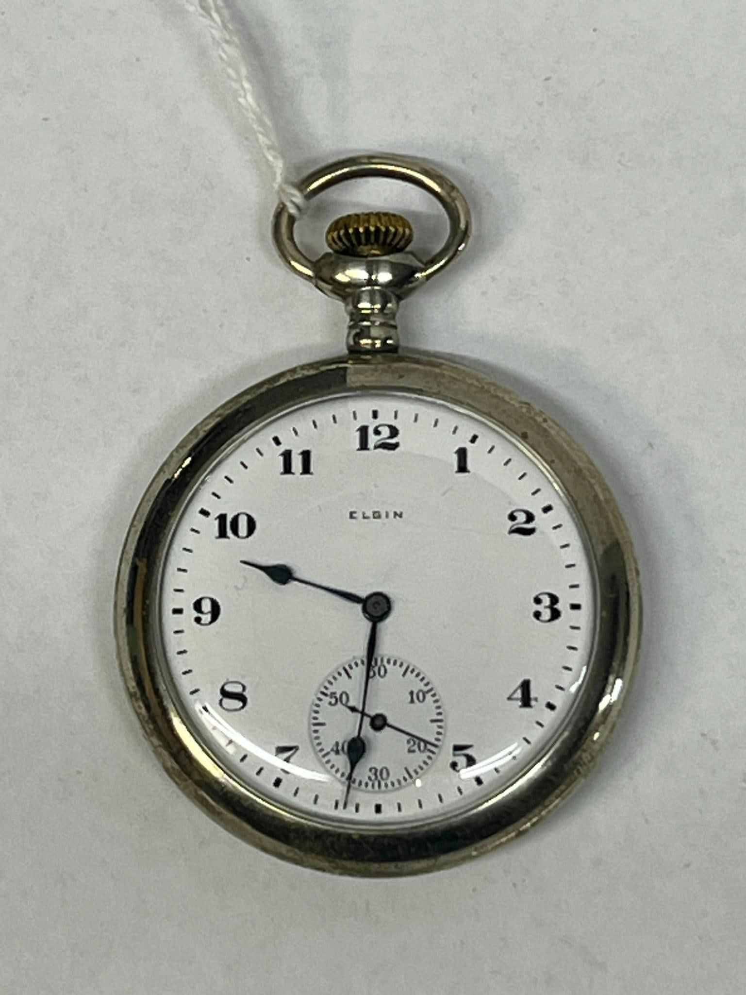 Elgin 17-Jewel Open-Face Pocket Watch: An open-face pocket watch featuring a manual wind 17-jewel movement. The dial is marked ELGIN below the twelve o'clock position. The hour and minute hands are blued steel spade hands, while the