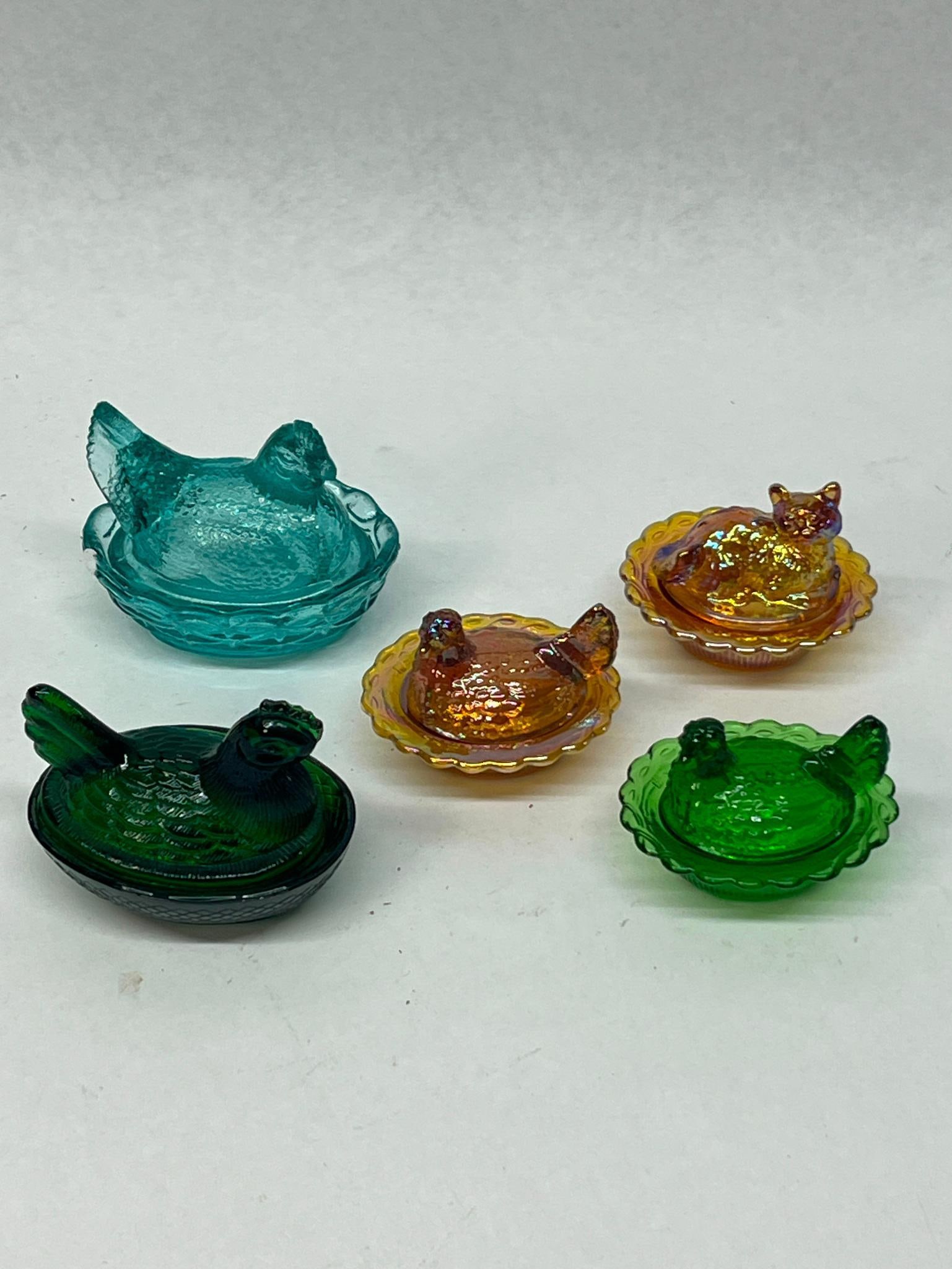 Set 5 Glass Hen on Nest & Cat Dishes: A group of five miniature pressed glass animal-themed covered dishes. The collection includes a large turquoise aqua glass hen on nest featuring a basket-weave patterned base and a molded starburst de