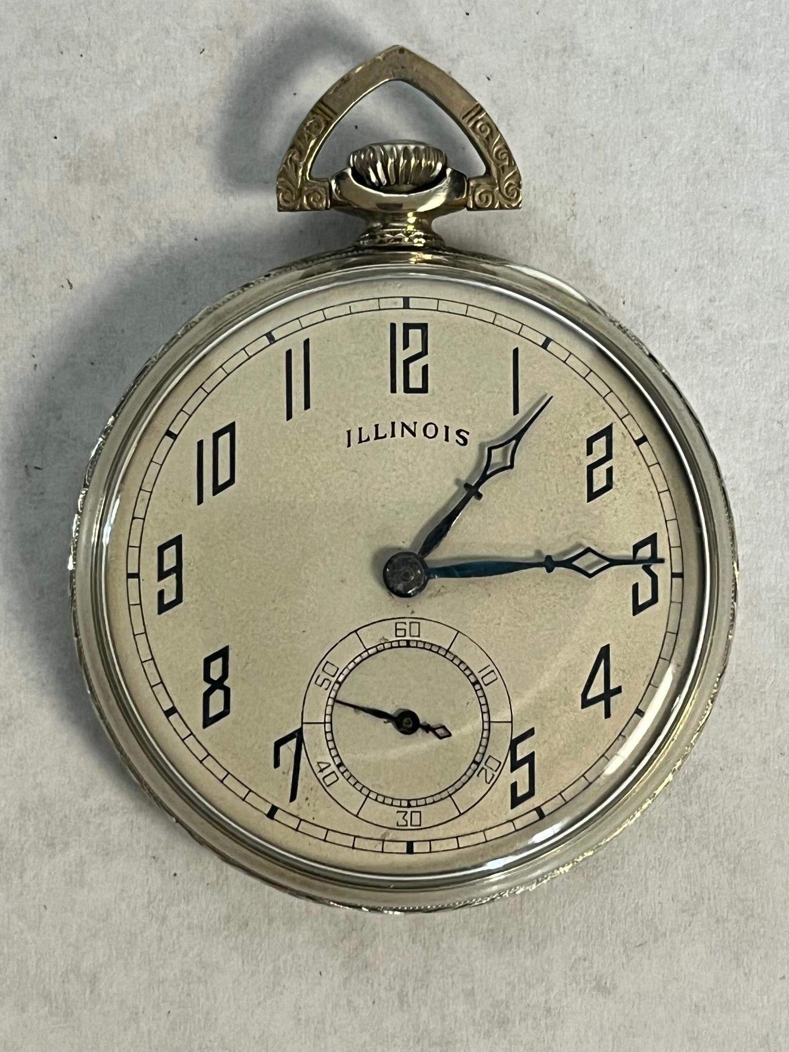 Illinois A. Lincoln 14K Gold Fill Watch: An American open-face pocket watch featuring a 14 karat gold filled case and a high-grade mechanical movement. The off-white metal dial is marked with the name ILLINOIS and features stylized Art Deco 