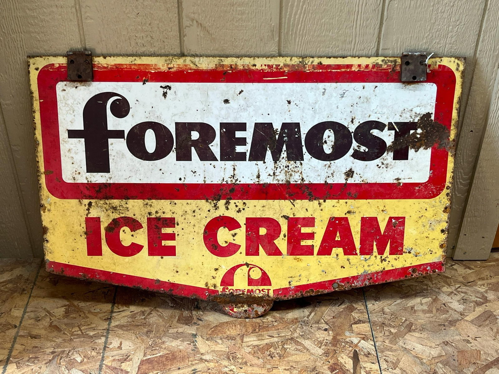 Foremost Ice Cream Metal Flange Sign: This is a double sided metal advertising sign produced for Foremost Ice Cream. The upper portion consists of a white rectangular field enclosed by a red border, displaying the brand name printed in a 