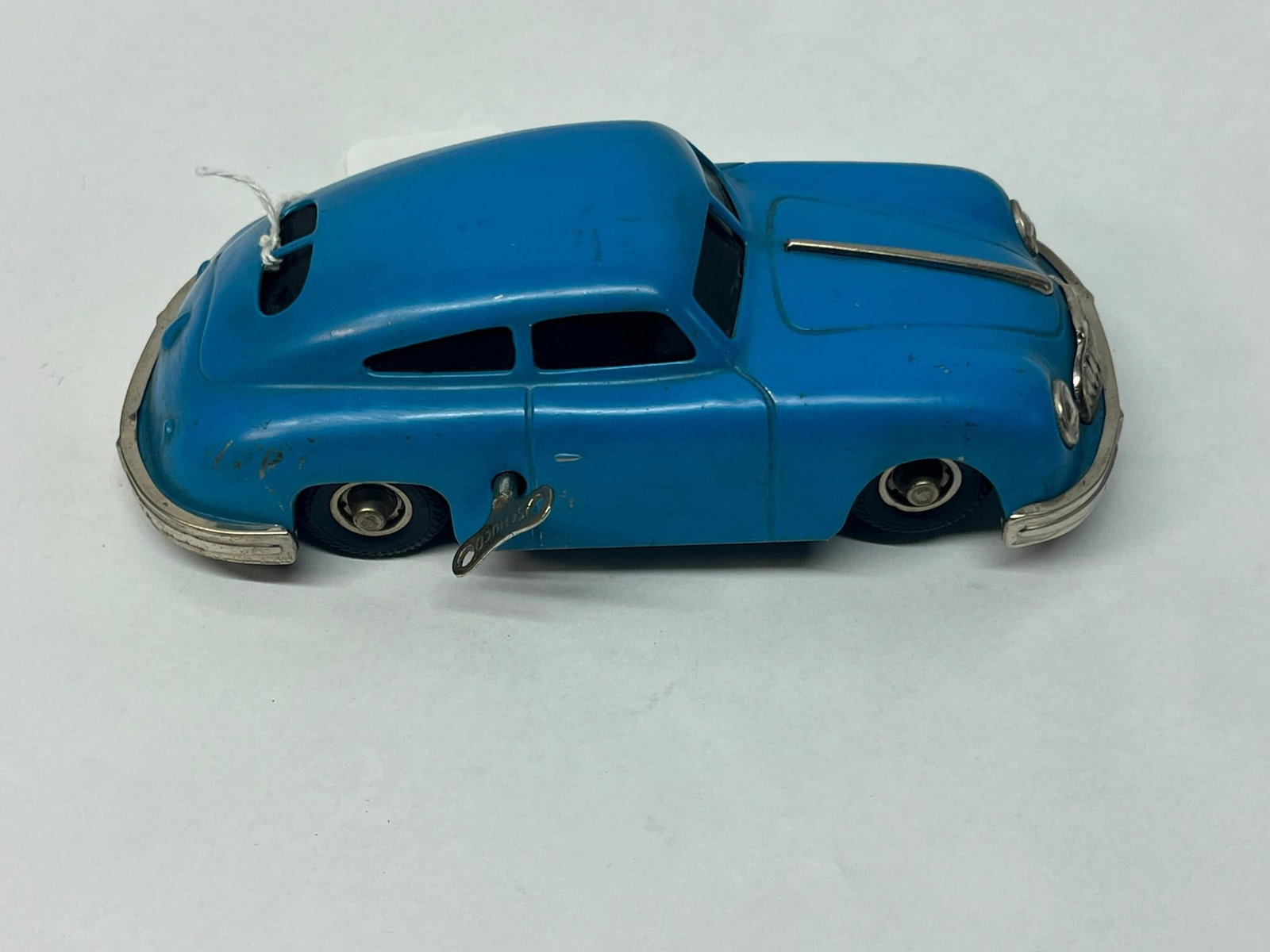 Gescha Sixmobil 557 Clockwork Toy Car: A Western German clockwork toy car constructed of lithographed tinplate with chrome-finished metal trim and rubber tires. The baseplate is marked at the right edge with MADE IN WESTERN GERMANY. The mo
