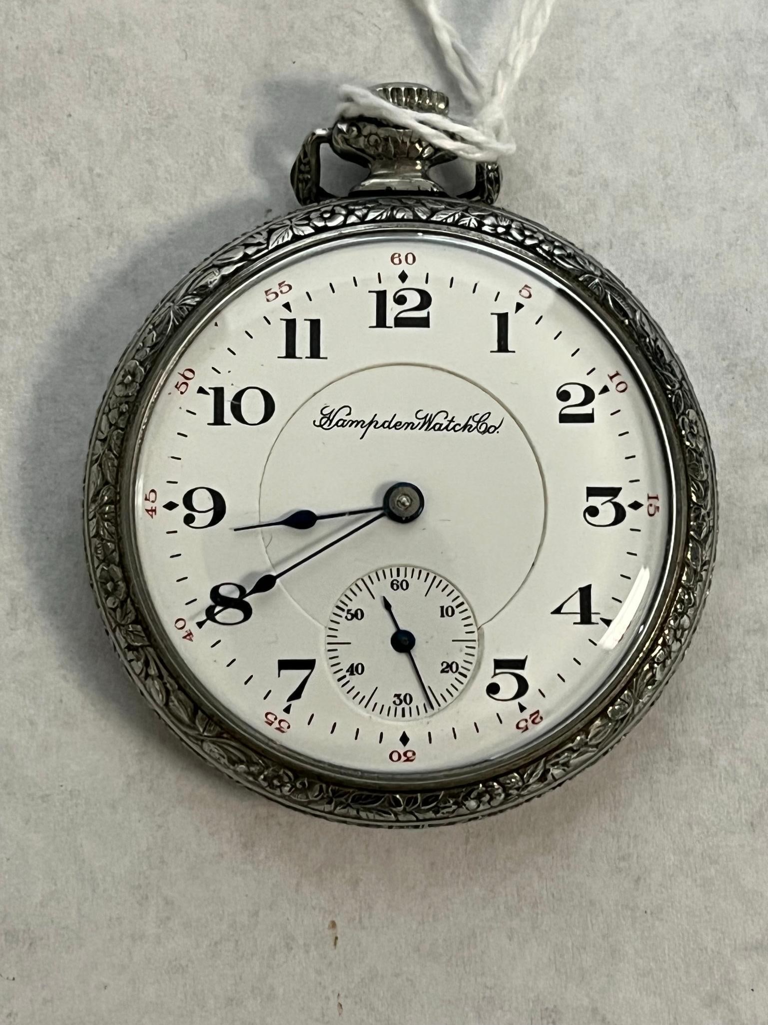 Jewel Nickel Pocket Watch" (36: This is an open-face pocket watch featuring a white enamel dial with black Arabic hour numerals and a red outer minute track marked in five-minute intervals. The dial includes a subsidiary seconds