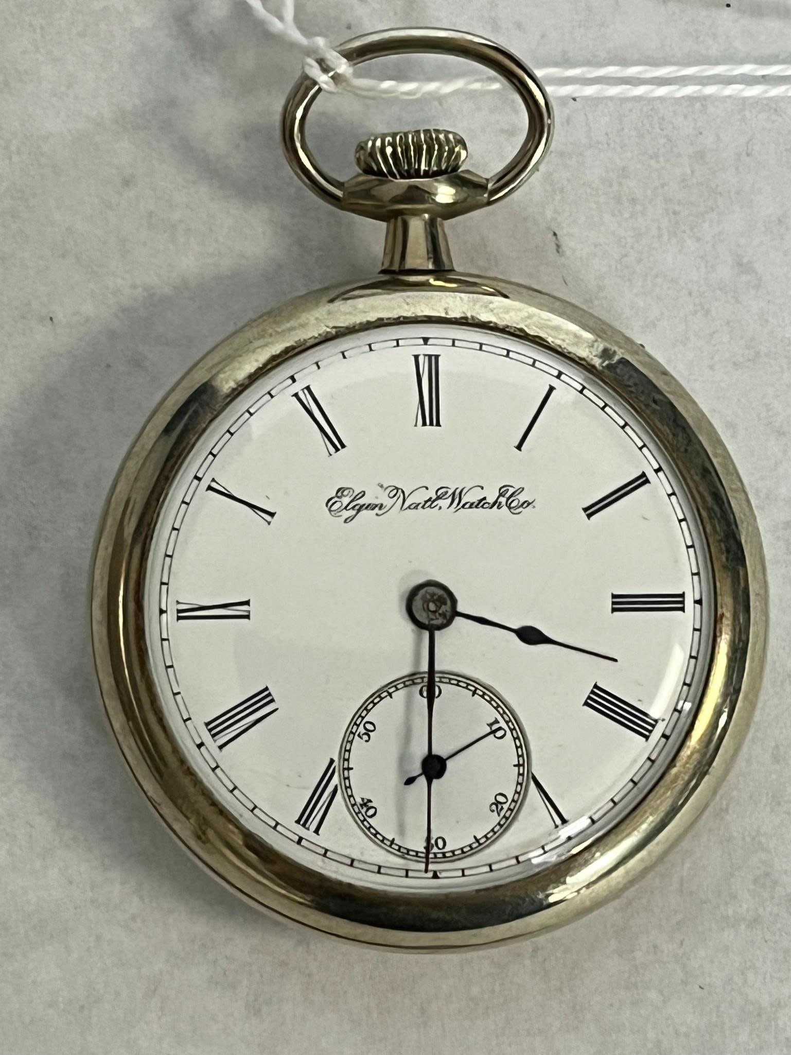 Elgin Wheeler 17 Jewel Pocket Watch: An American open-face pocket watch manufactured by the Elgin National Watch Company. The dial is signed in black script Elgin Natl Watch Co. below the twelve o'clock position and is fitted with blued