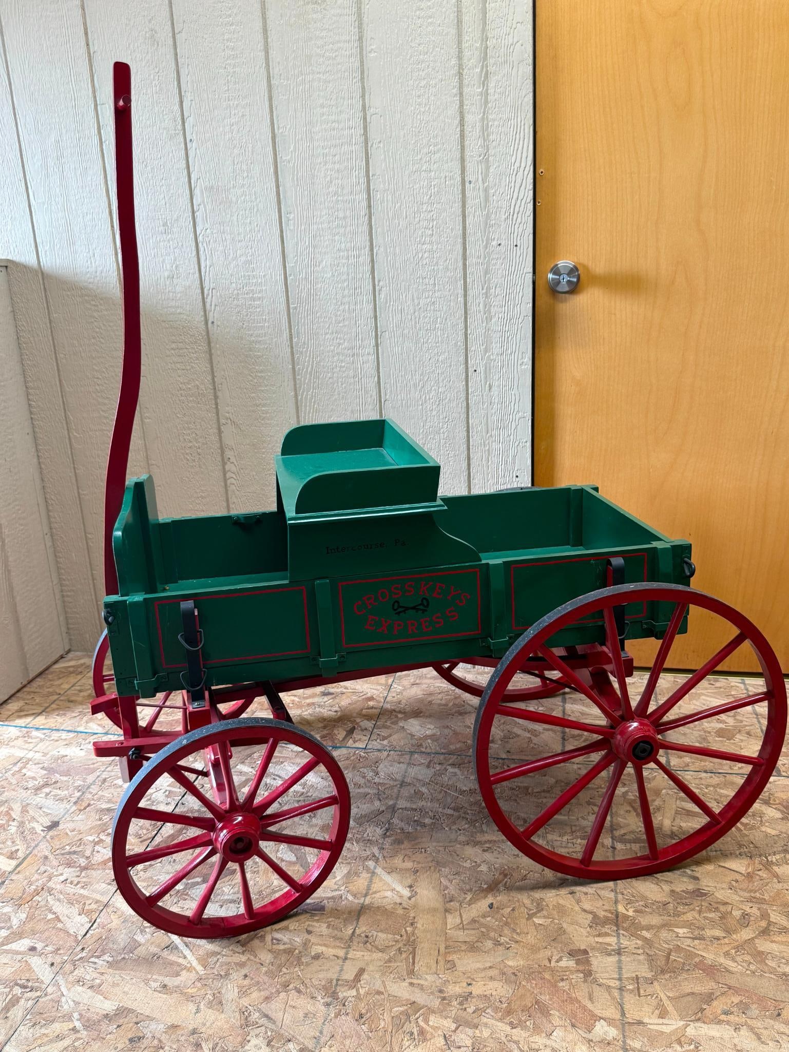 Crosskeys Express Wooden Delivery Wagon: This child's delivery-style wagon is constructed from green-painted wood with a red-painted chassis and wheels. A printed red logo on the side panels within a rectangular border reads CROSSKEYS