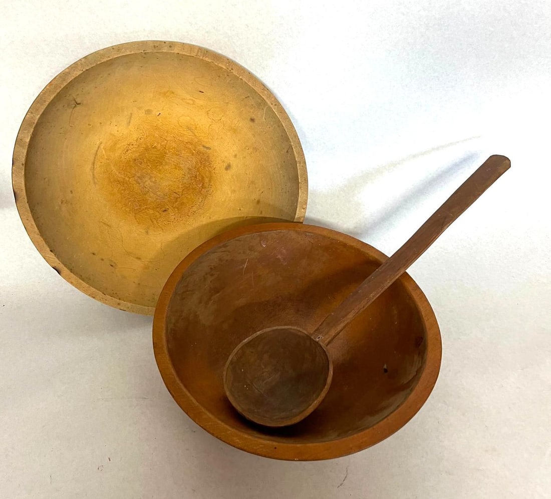 Munising Bowl & American Woodenware: This trio of American kitchen woodenware comprises two lathe-turned bowls and a hand-carved spoon. The larger bowl is turned wood with a deep, rounded profile and a warm, reddish-brown finish. The