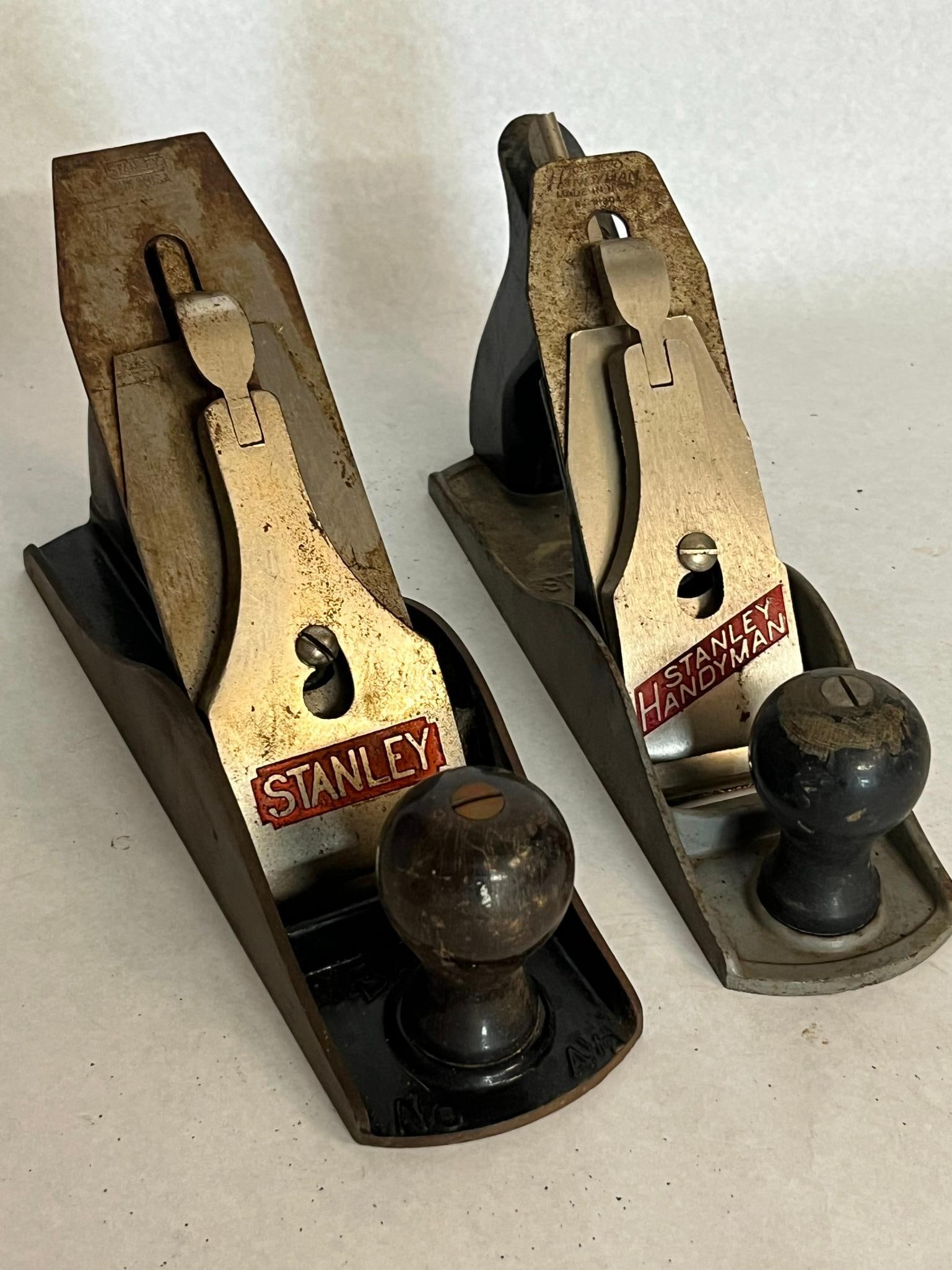 Pair Stanley Handyman Bench Planes: This lot comprises two American-made cast iron bench planes manufactured by Stanley. The lever cap bears a red rectangular logo reading STANLEY. Its steel iron is stamped at the top with a notched rec