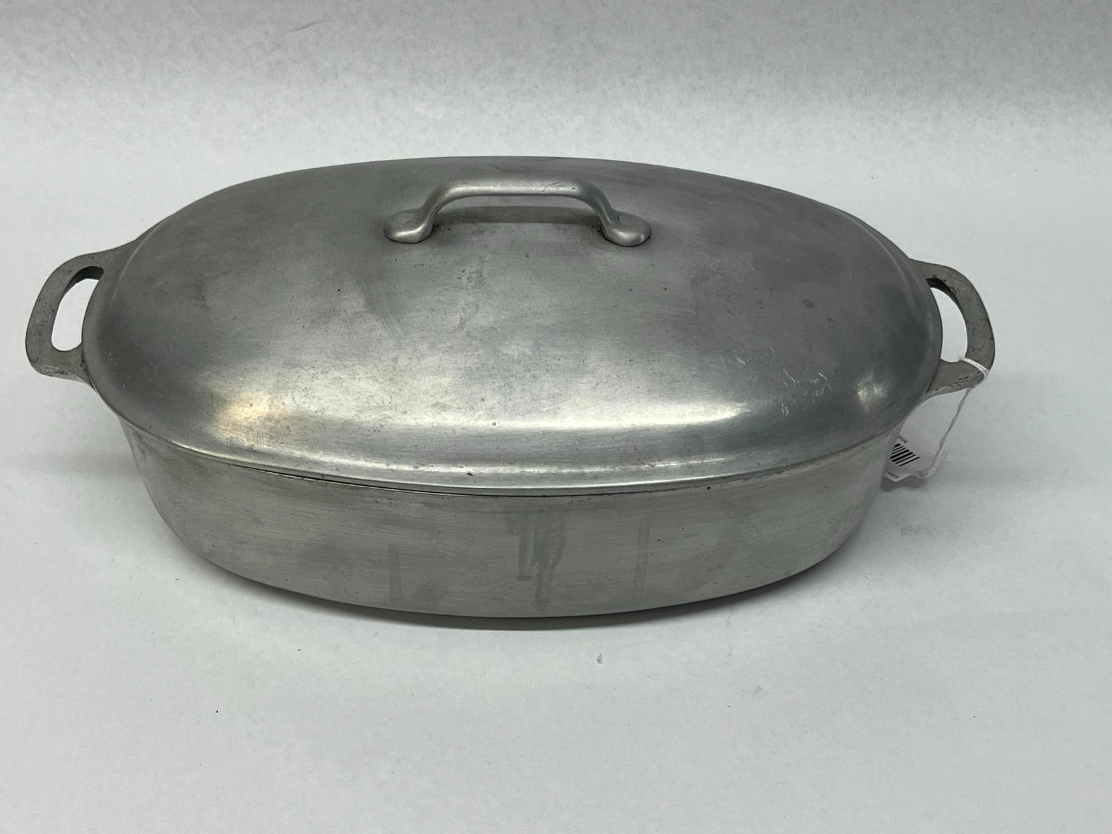 Griswold Oval Aluminum Roaster w/ Lid: A size 3 cast aluminum oval roaster produced by the Griswold Manufacturing Company, complete with its original matching lid and internal cast iron trivet. The exterior bottom of the base is impressed