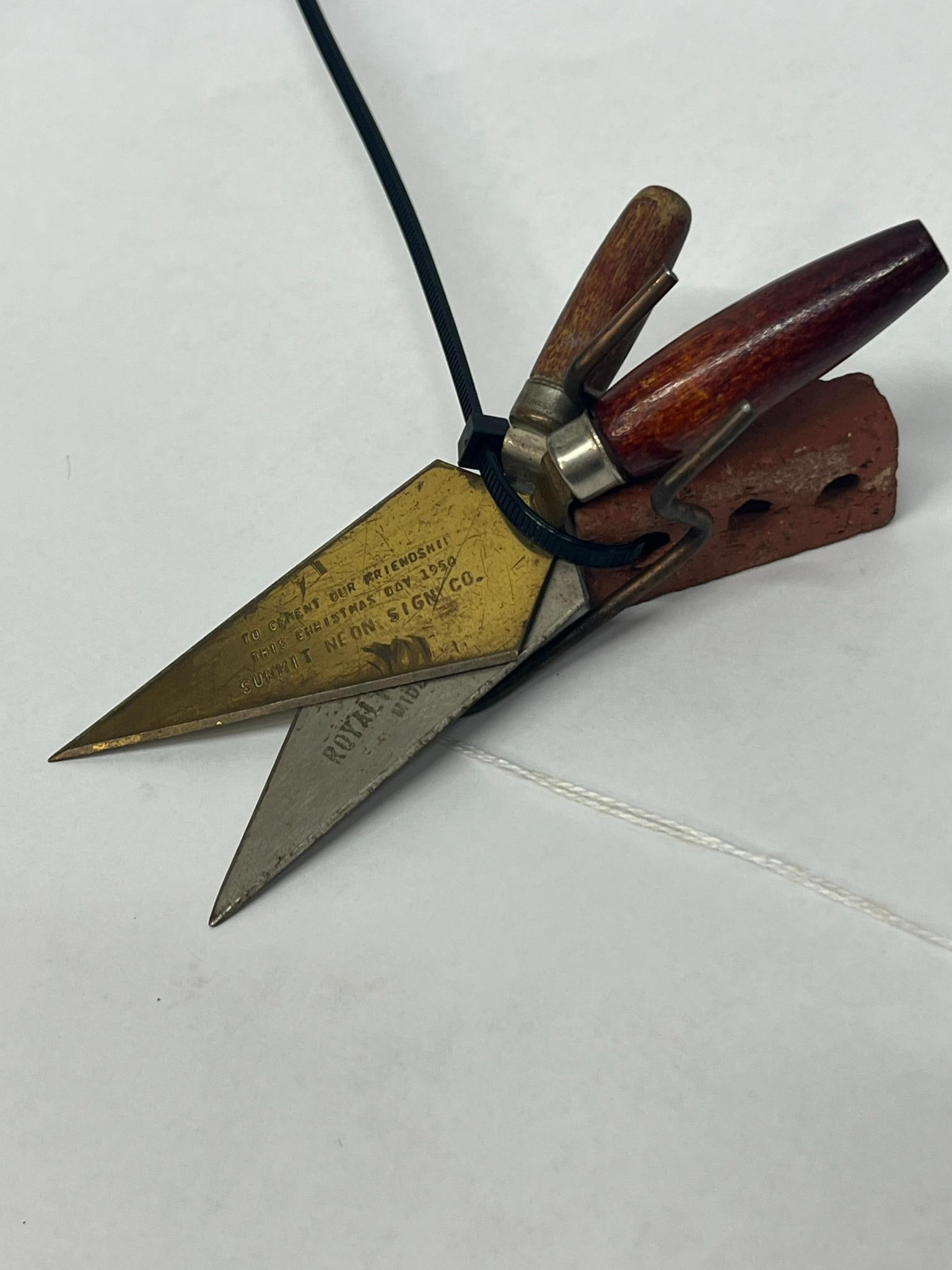3 Masons Trowels & Belden Brick Co: A trio of promotional advertising items comprising two miniature masons trowels and a miniature brick. The first trowel features a brass-toned metal blade and a turned wooden handle. Above the text