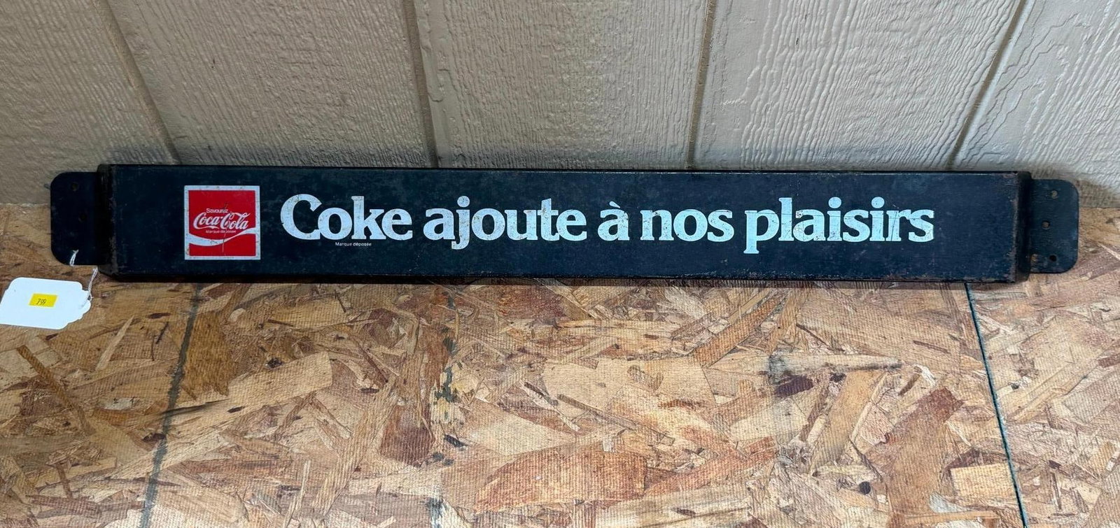 French Coca-Cola Metal Door Push Bar: A enameled metal advertising door push bar for Coca-Cola featuring French language text. The sign is constructed from a long rectangular metal piece with angled mounting flanges at each end. The main 