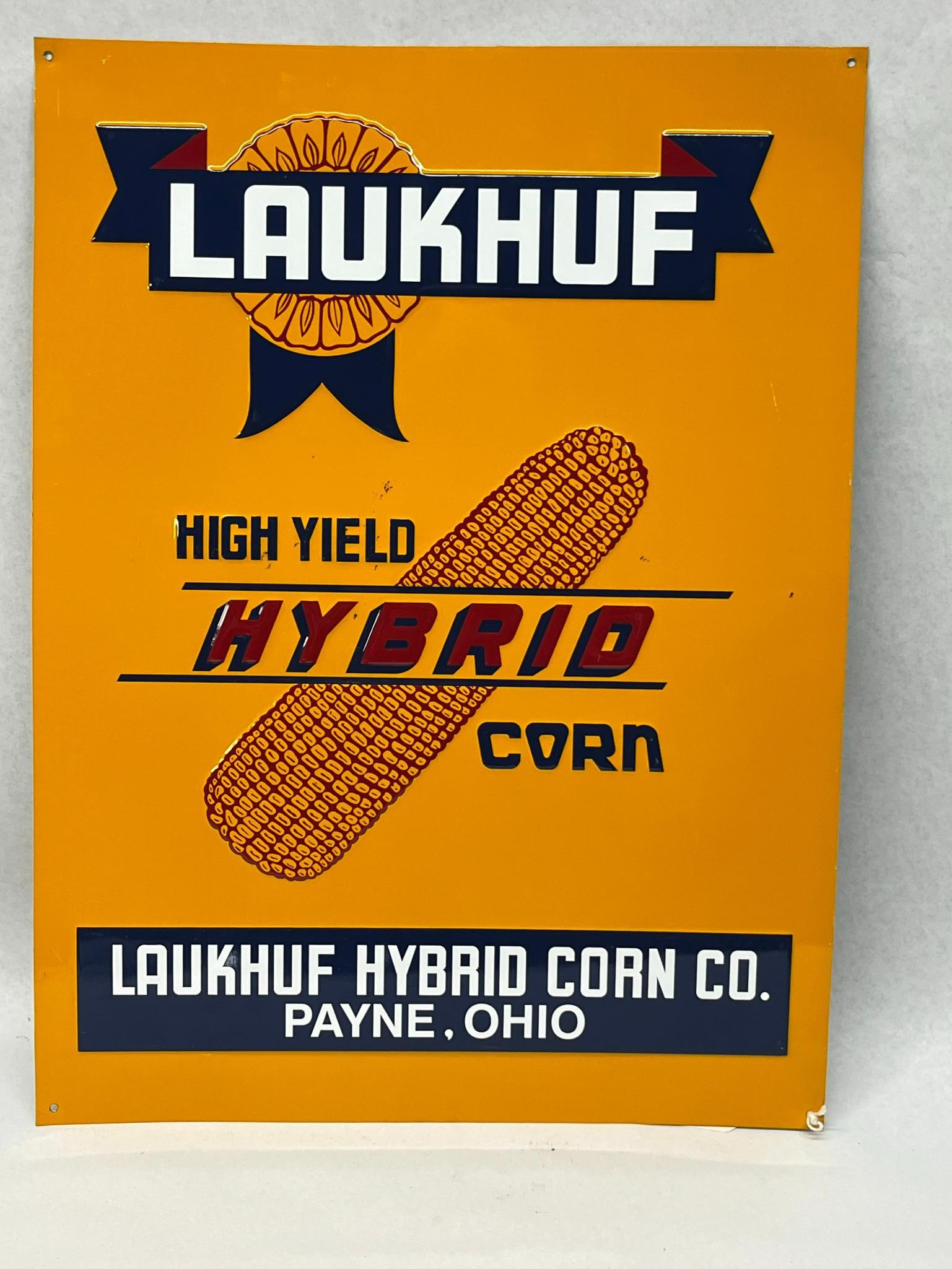 Laukhuf Hybrid Corn Embossed Tin Sign: A mid-twentieth-century rectangular embossed tin advertising sign for the Laukhuf Hybrid Corn Company of Payne, Ohio. The text HIGH YIELD appears in dark blue to the left, and the word CORN is embosse