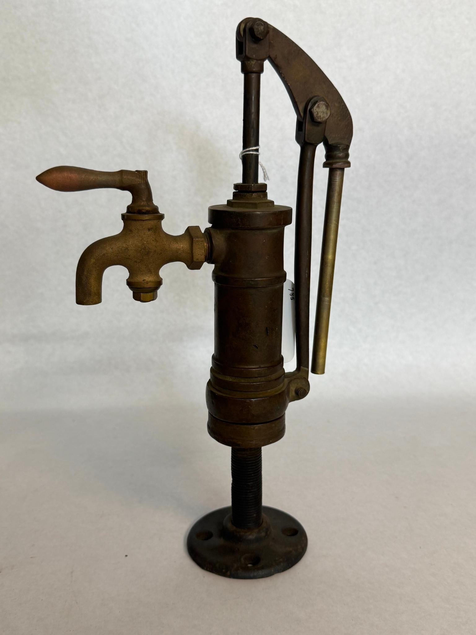 B. Sands & Son Brass Marine Galley Pump: This manual lever-action galley pump is constructed from cast brass and bronze with a steel piston rod and a cast iron mounting flange. The unit features a vertical piston mechanism operated by a curv