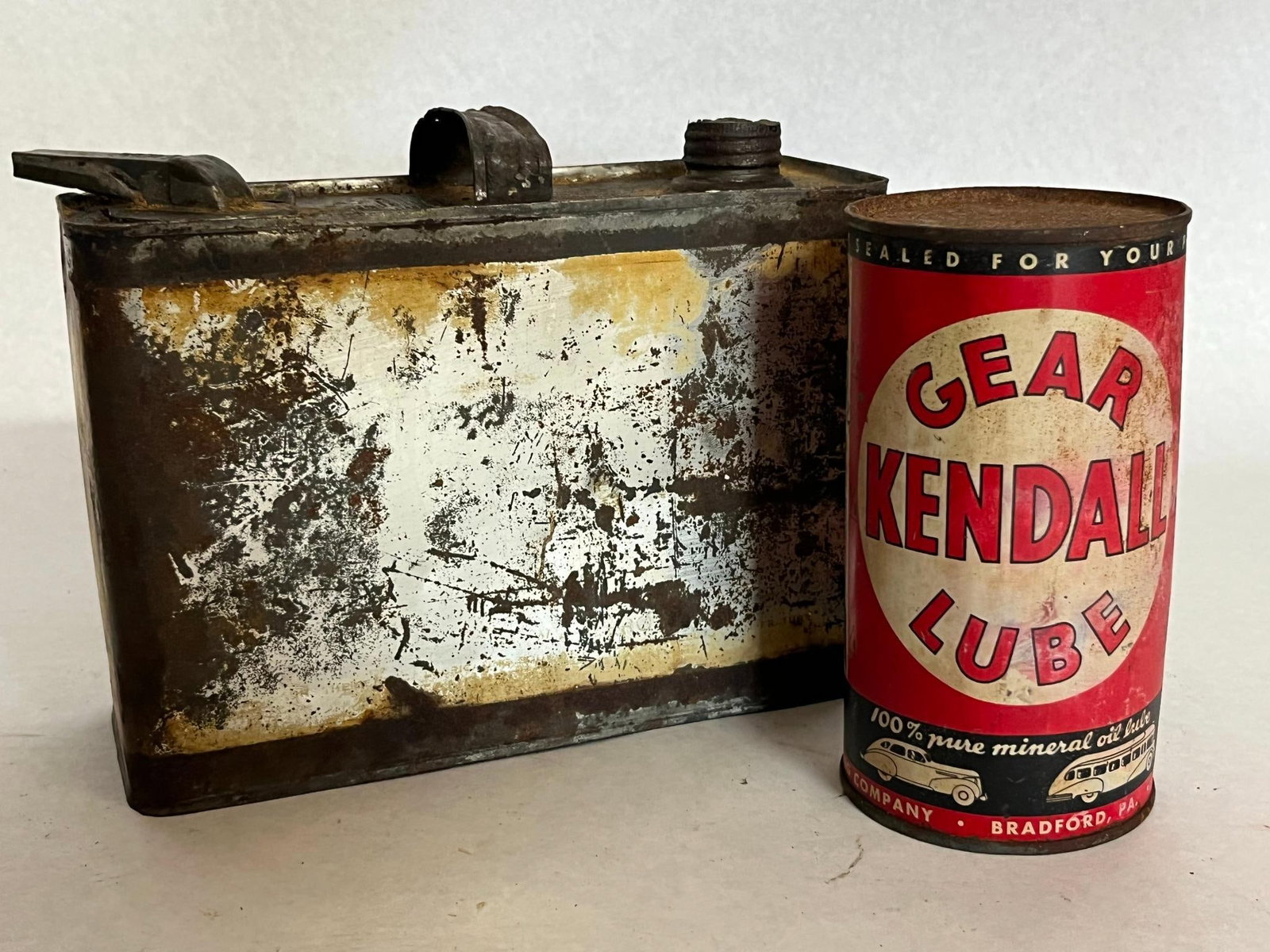 Pair Polarine & Kendall Lubricant Cans: This lot features two American metal lubricant containers from the early to mid-20th century. The yellow-painted exterior includes printed text for Polarine Transmission Oil, Transmission Grease, Cup
