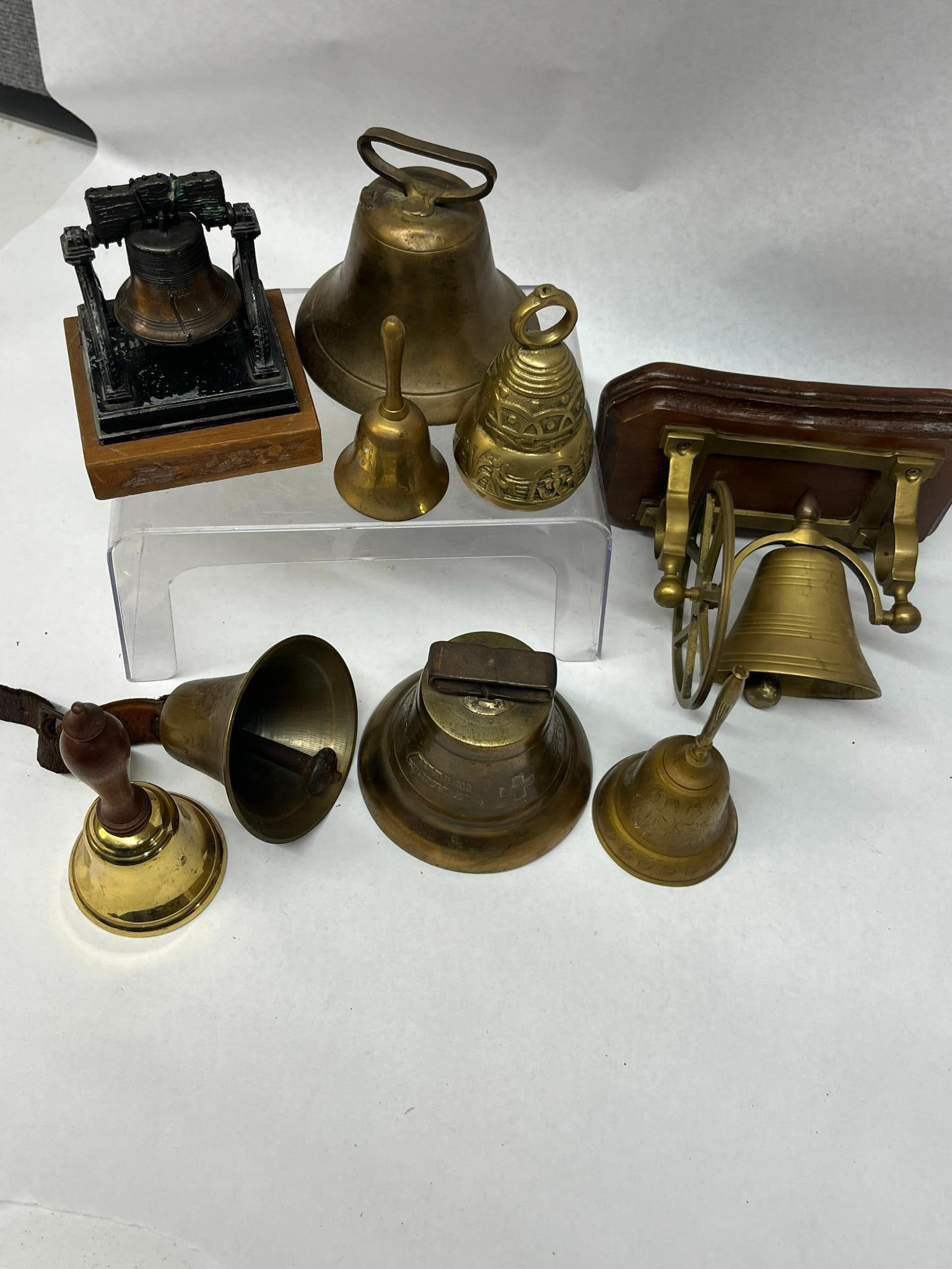 Brass & Metal Swiss & Liberty Bells: A diverse group of brass and metal bells featuring various styles and mounting methods. The bell body features relief characters reading PASS AND STOW / PHILADA / MDCCLIII and LIBERTY BELL. A