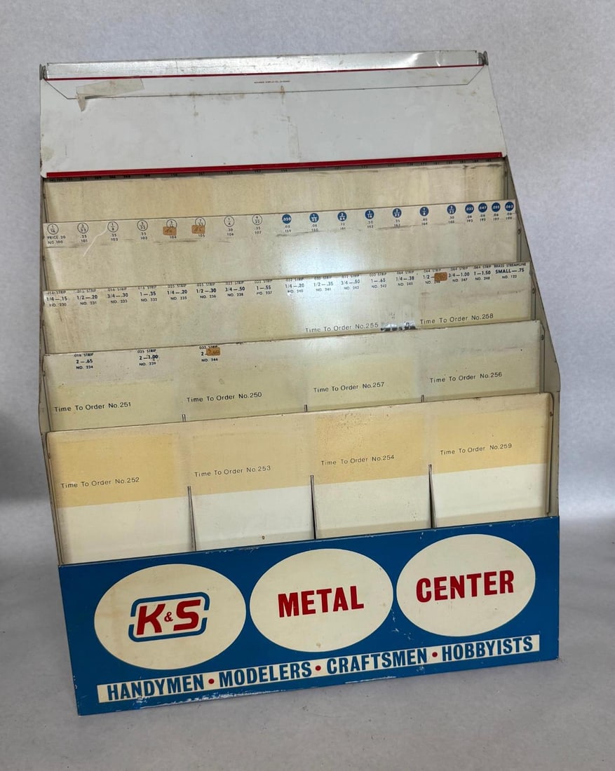Advance Display Co. K&S Tiered Rack: A multi-tiered retail display rack designed for K&S Metal Center products. The unit is constructed from painted sheet metal with a slanted, tiered interior designed to hold various hobbyist metal