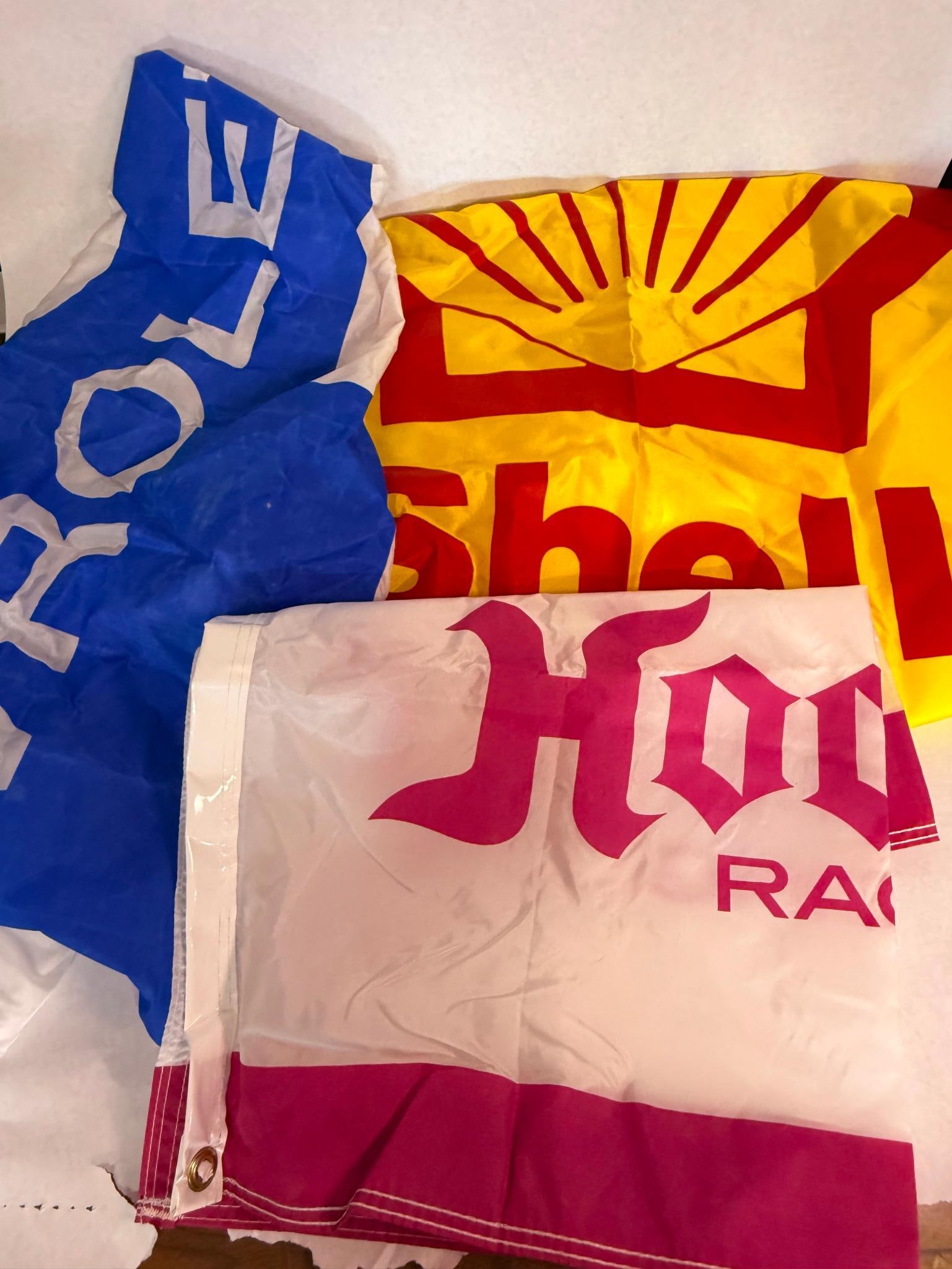 Shell, Chevrolet & Hoosier Auto Flags: This lot consists of three promotional automotive flags intended for garage or workshop display. The flags are constructed from a lightweight synthetic fabric with white canvas headers and double-row