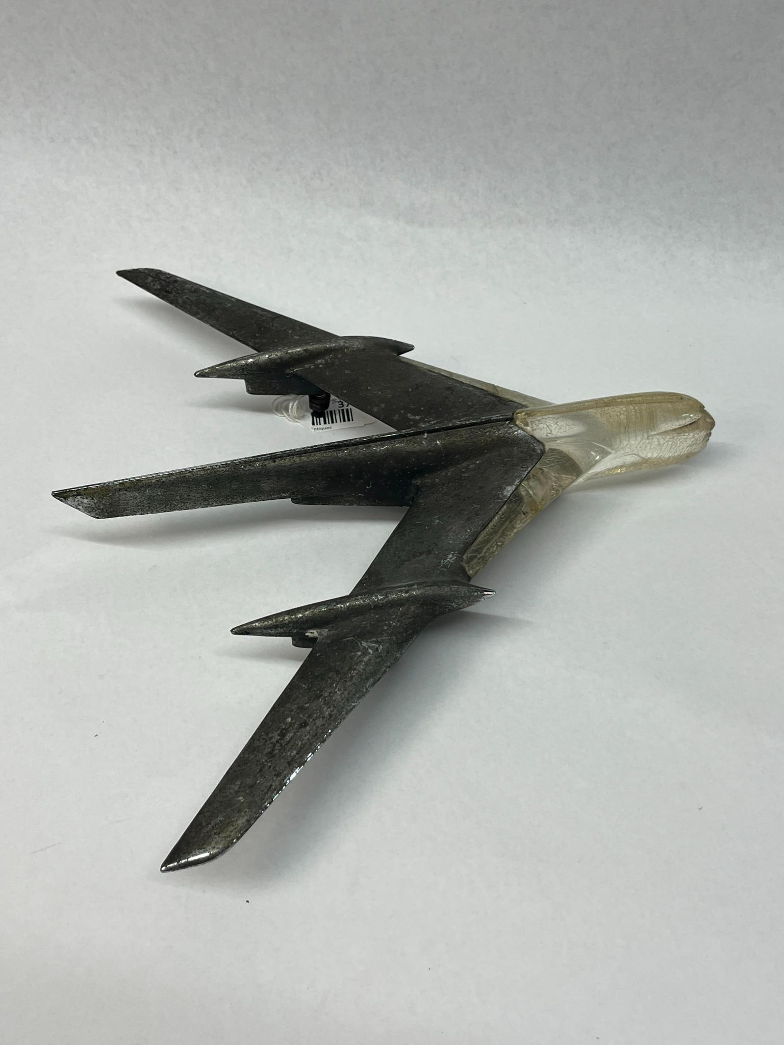 Mid-Century Jet-Style Hood Mascot: An automotive hood mascot from the mid-20th century, designed in the form of a swept-wing jet aircraft. The die-cast metal body features a central vertical fin and two smaller auxiliary fins on the