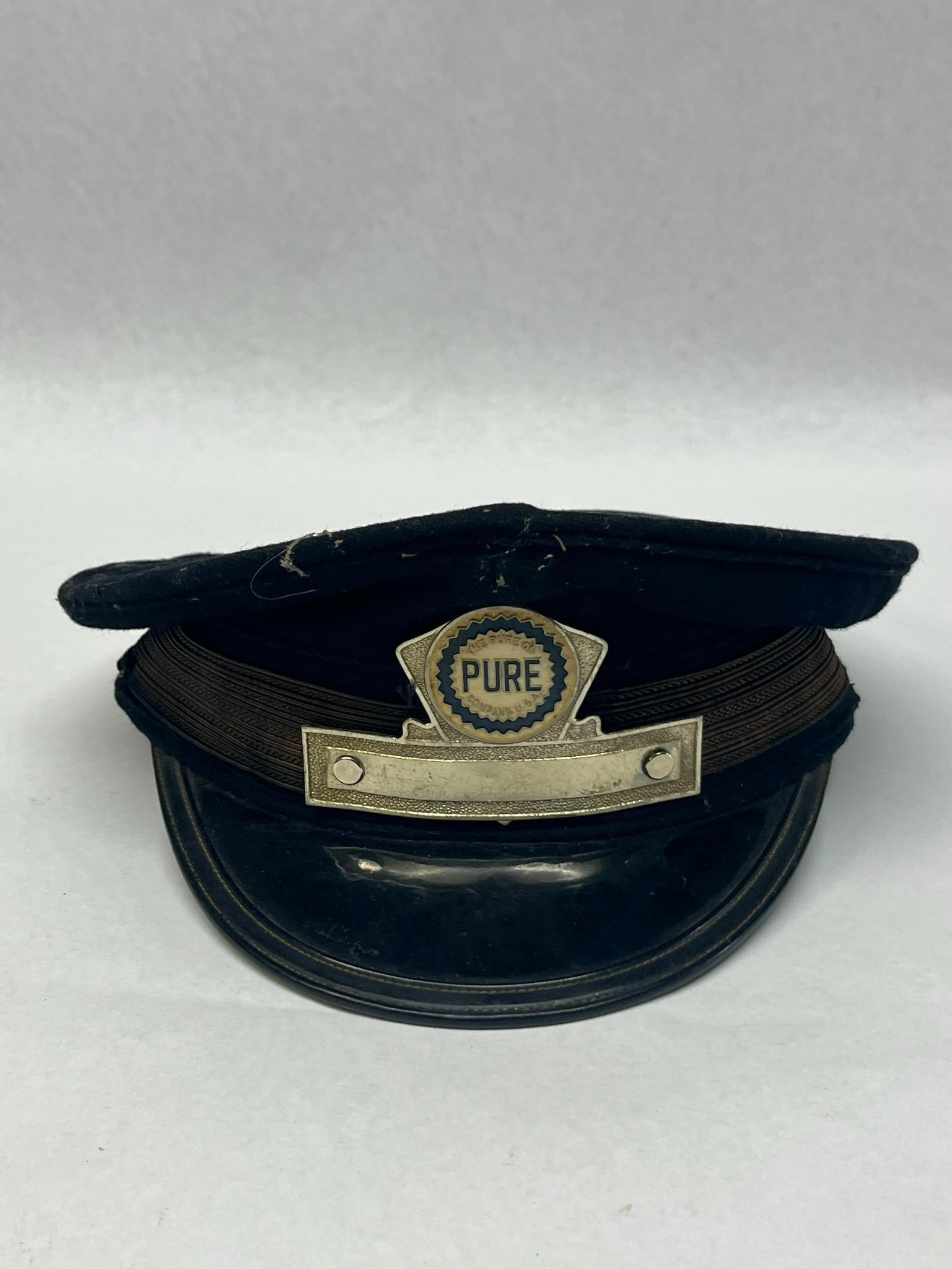 Pure Oil Service Cap, Ikeda Shoten: This service station attendant cap, designed in a peaked chauffeur style, is a mid-twentieth-century uniform piece associated with the Pure Oil Company. The top portion of the badge is a scalloped