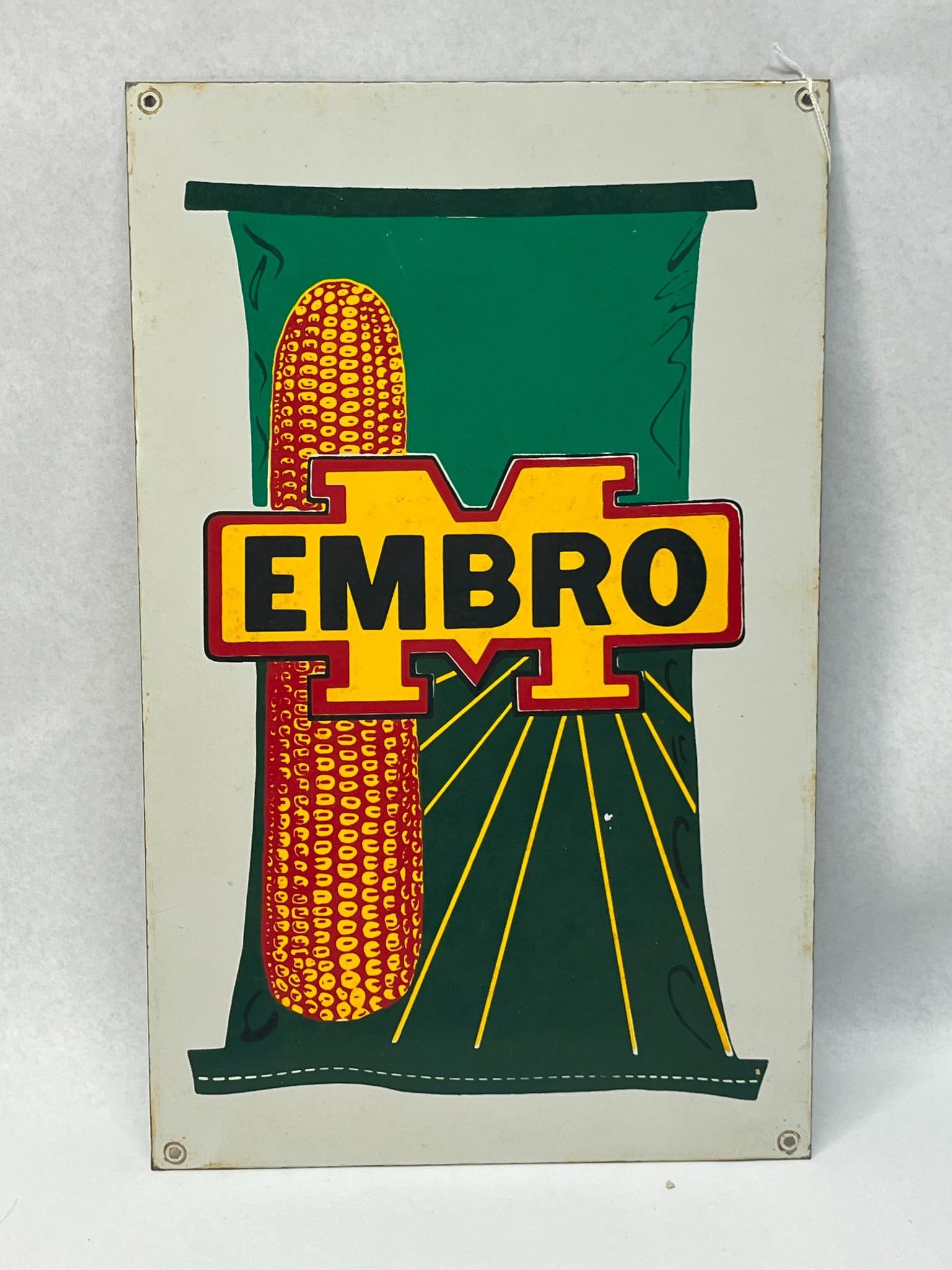 Embro Hybrid Seed Corn Advertising Sign: A rectangular painted metal advertising sign for Embro brand seed corn. The sign is made of a thin-gauge metal sheet and features four pre-drilled mounting holes, one in each corner. Dimensions: 14