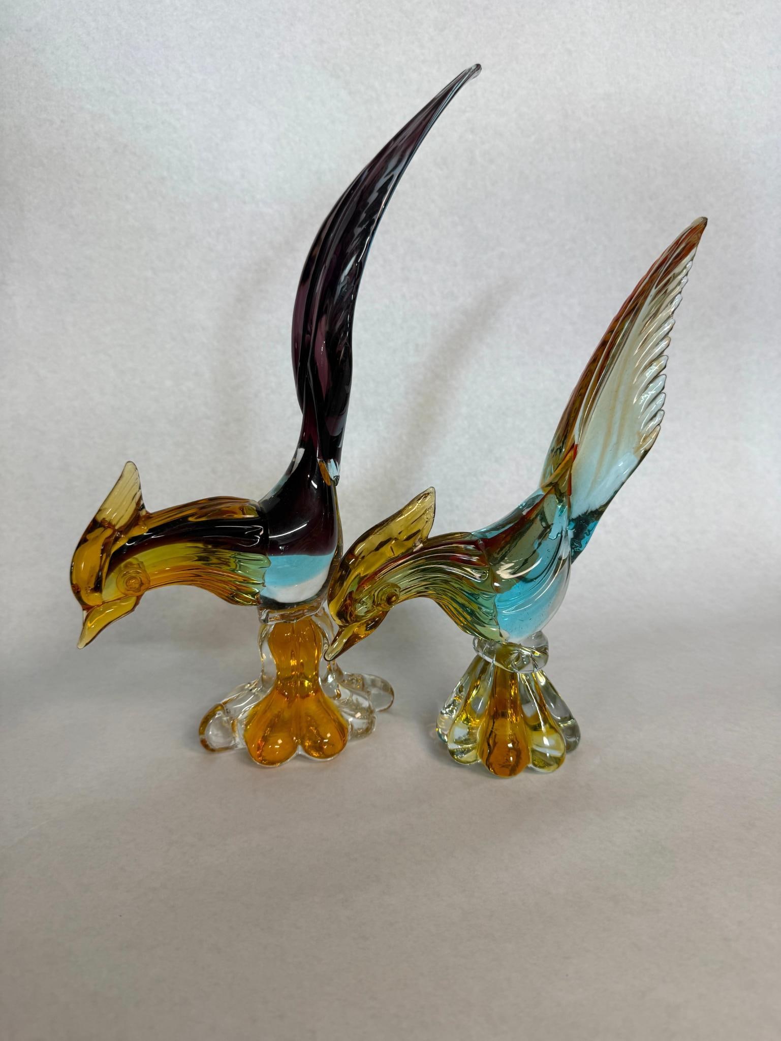 Pair Mid-C. Hand-Blown Glass Pheasants: A pair of hand-blown art glass bird figurines, stylized as pheasants or birds of paradise. Each figurine is constructed with internal layering and ribboning techniques to achieve a multi-colored