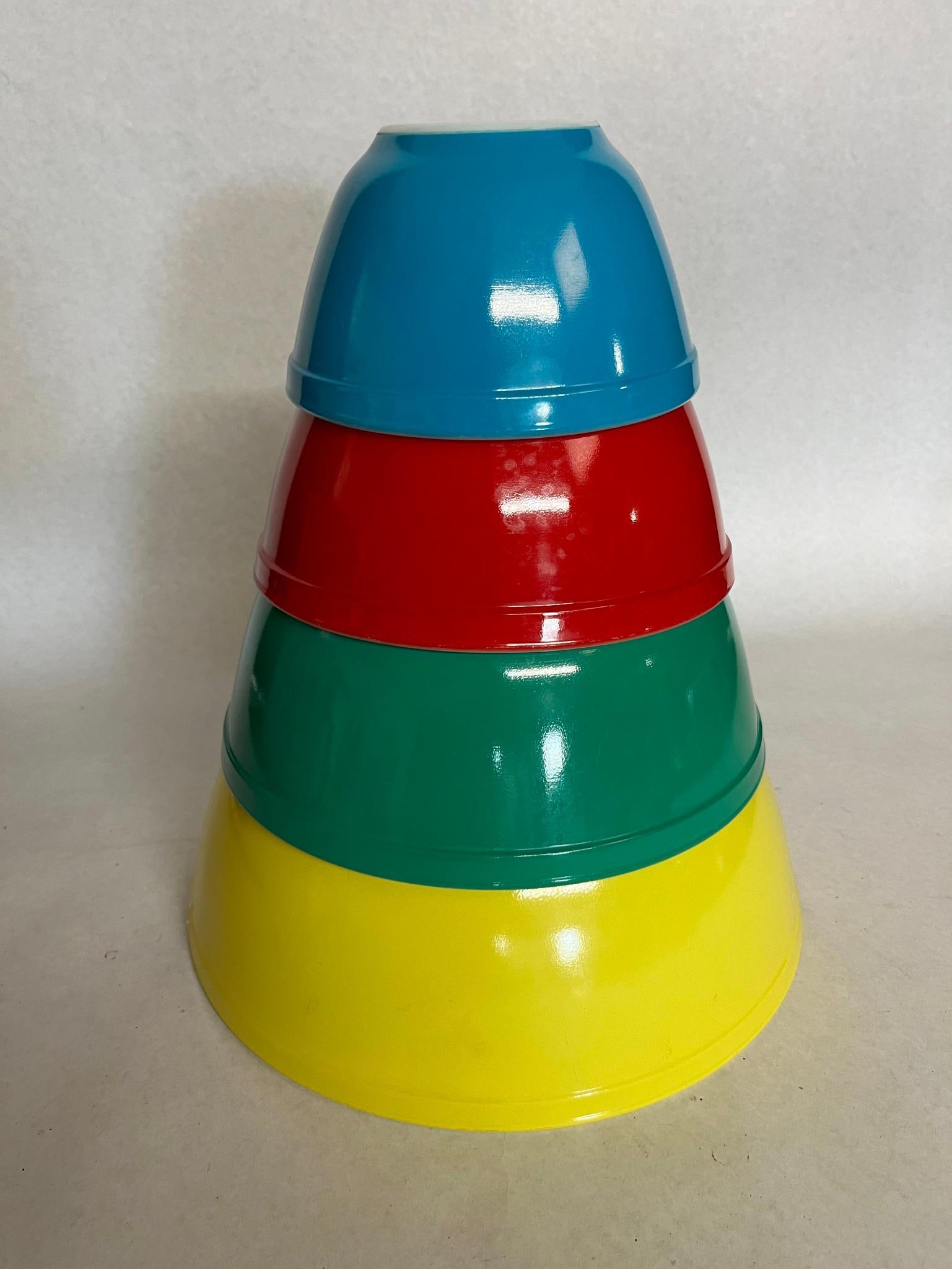 Set 4 Pyrex Primary Colors Mixing Bowls: A set of four American-made nesting mixing bowls produced in opaque white glass with fired-on color finishes. An impressed mark on the circular base of the blue bowl reads 401 1 1/2 PT. TRADE MARK 4 P