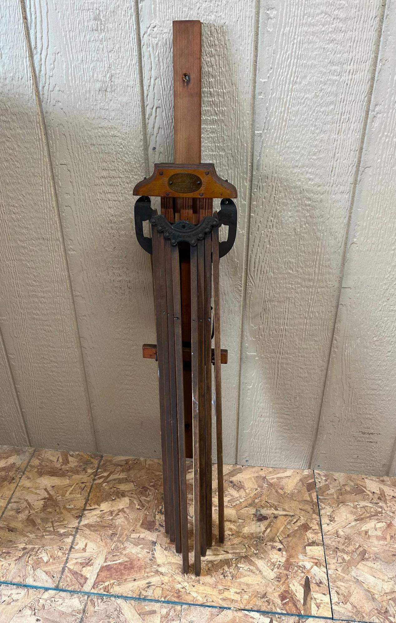 L. Hopkins Perfection Wall Drying Rack: An antique wall-mounted clothes drying rack of American manufacture. An oval brass plaque secured to the wooden headpiece is impressed with the text PERFECTION CLOTHES DRIER, PATENTED, L. A