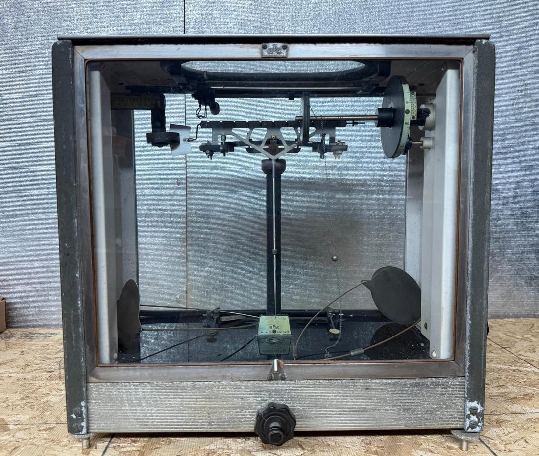 American Balance Chainomatic Scale: This analytical balance scale is a precision scientific instrument manufactured in the United States. The device is housed within a textured gray metal case featuring glass viewing panels on the