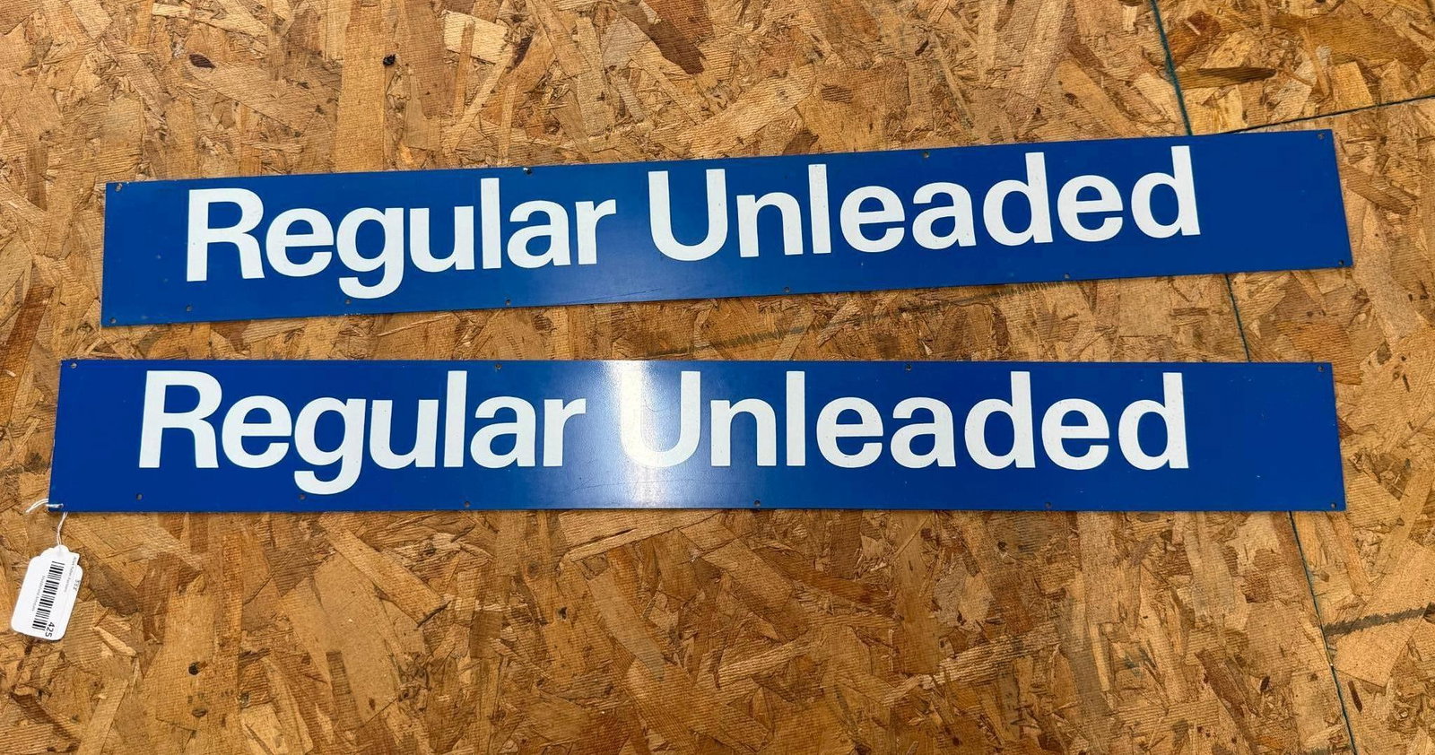 Pair Unleaded Gasoline Pump Grade Signs: A matching pair of gasoline pump grade identification signs. Each sign is constructed from painted metal and features a solid blue background with the text Regular Unleaded centered in white sans-seri