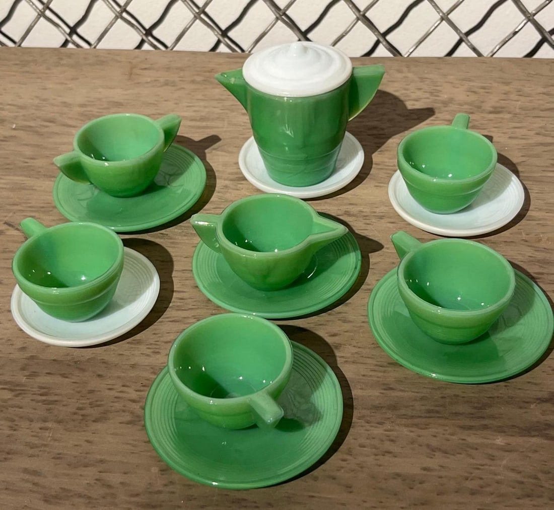 16pc Green & White Slag Glass Tea Set: This 16-piece miniature child's tea set is crafted from opaque, marbleized green and white glass, featuring a distinctive concentric ring or ribbed pattern on the exterior surfaces. The collection inc