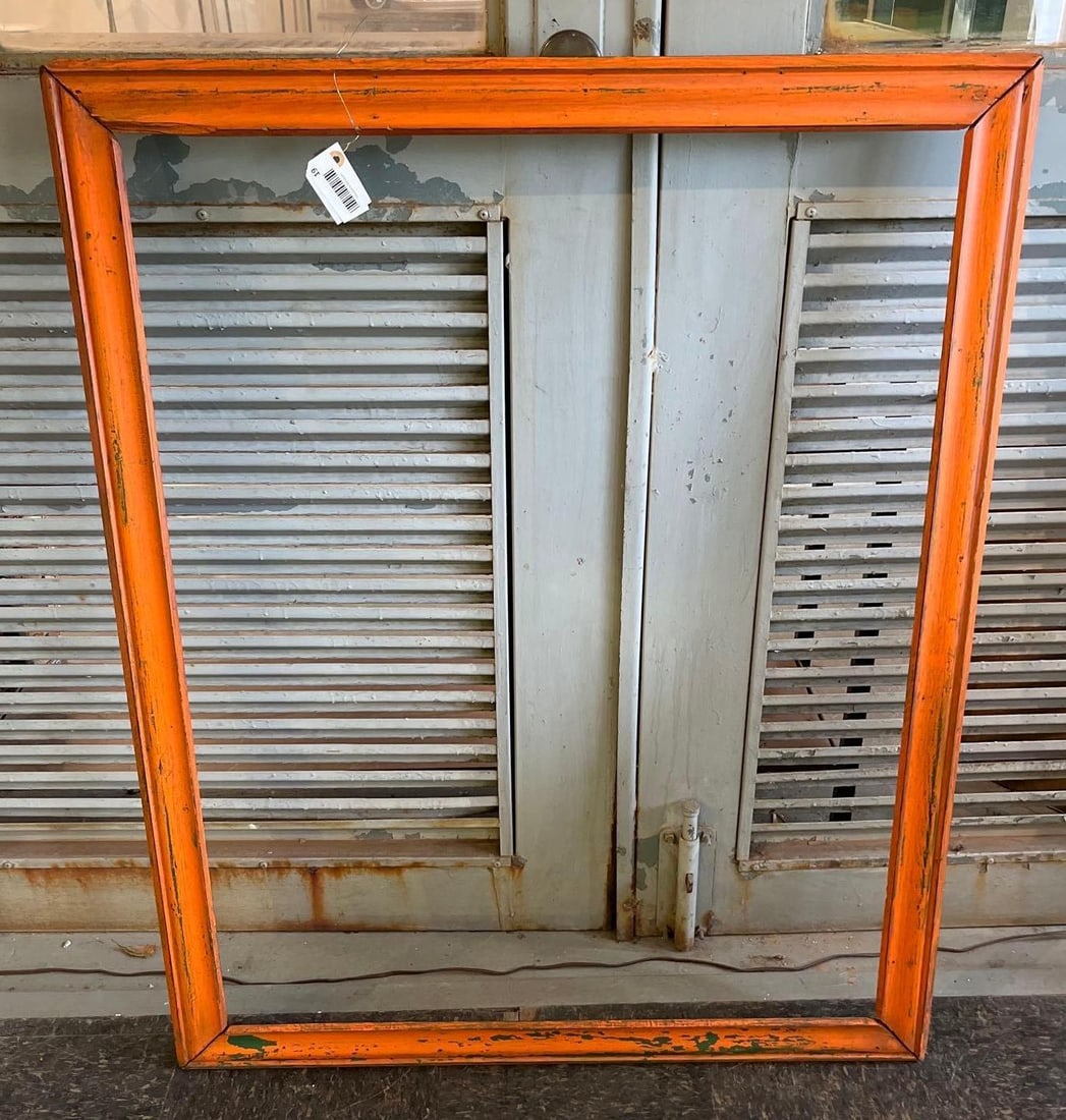 Orange & Green Painted Wooden Frame: This large wooden picture frame is constructed with a stepped and coved profile. The front surface features a vibrant orange paint finish applied over an underlying dark green layer, both of which sho