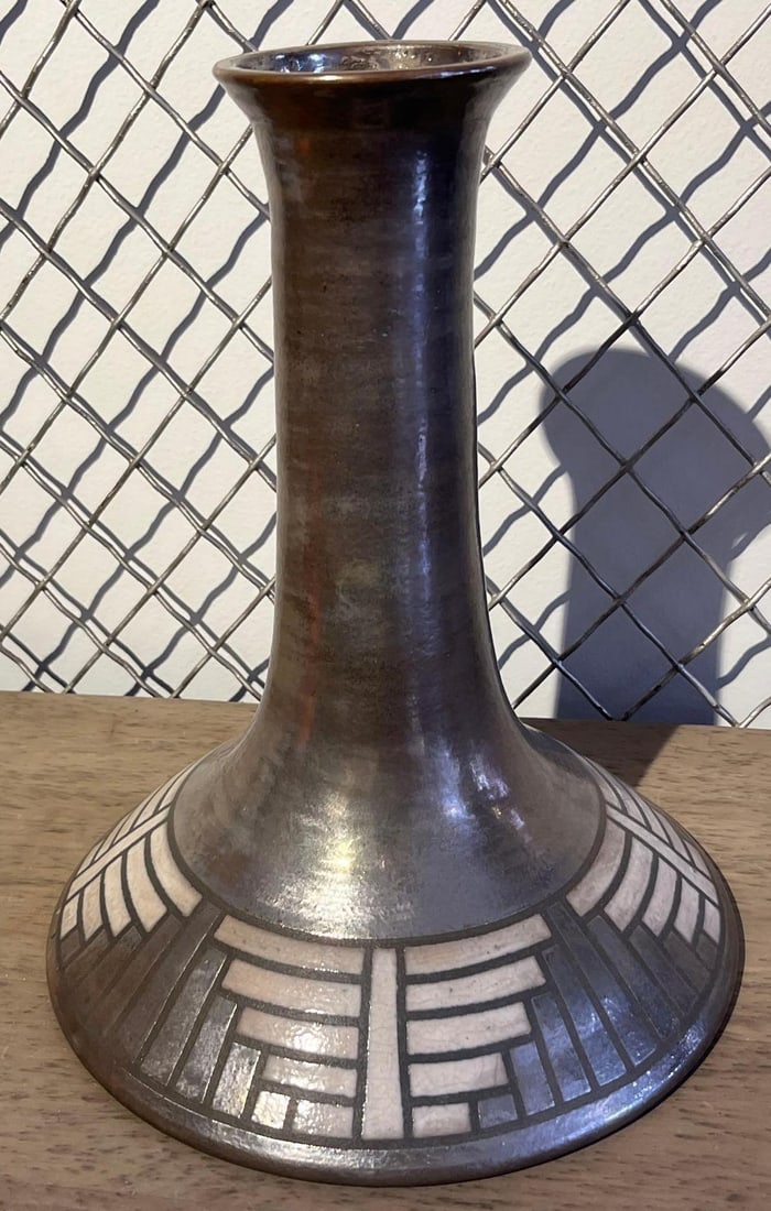Studio Pottery Luster Trumpet Vase: This studio pottery vase features a tall, slender trumpet neck that flares at the rim and tapers down to a broad, conical base. The exterior of the neck and upper portion of the base are finished in a