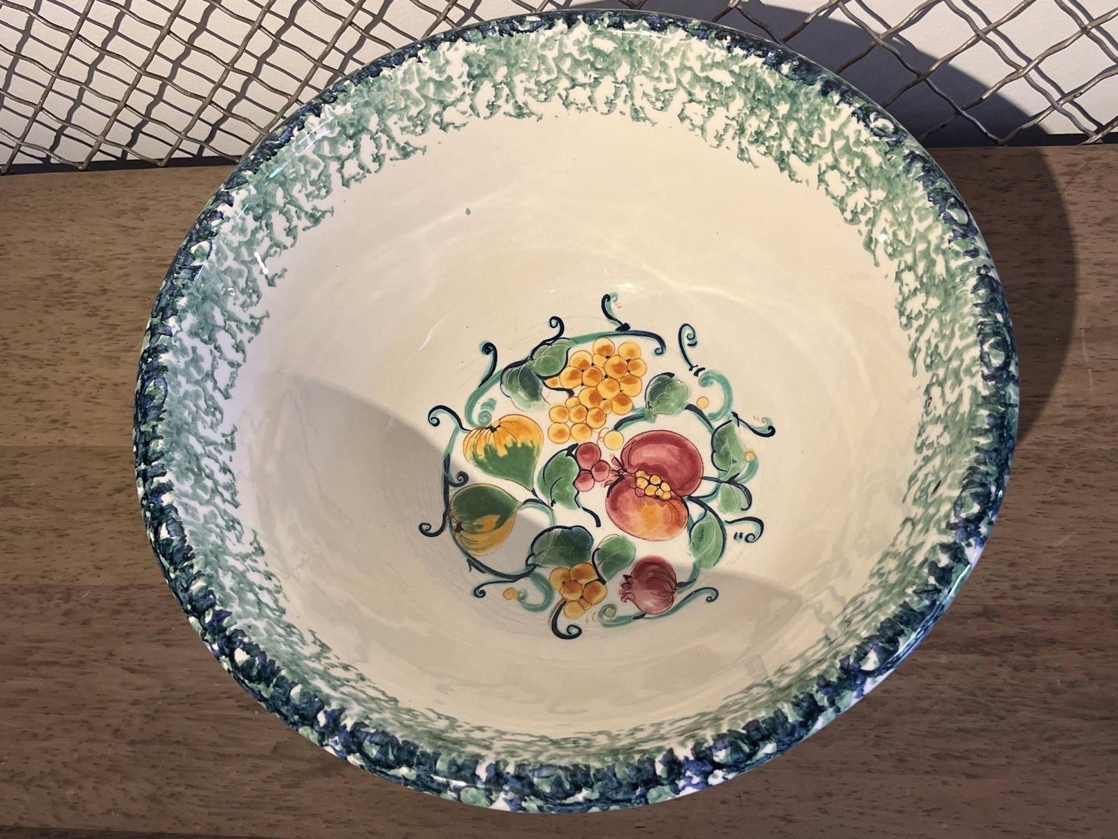 Due Torri S.C. Italian Ceramic Bowl: An Italian hand-painted earthenware serving bowl featuring a flared, tapered form resting on a footed base. The interior is decorated with a central fruit motif depicting clusters of yellow grapes, re