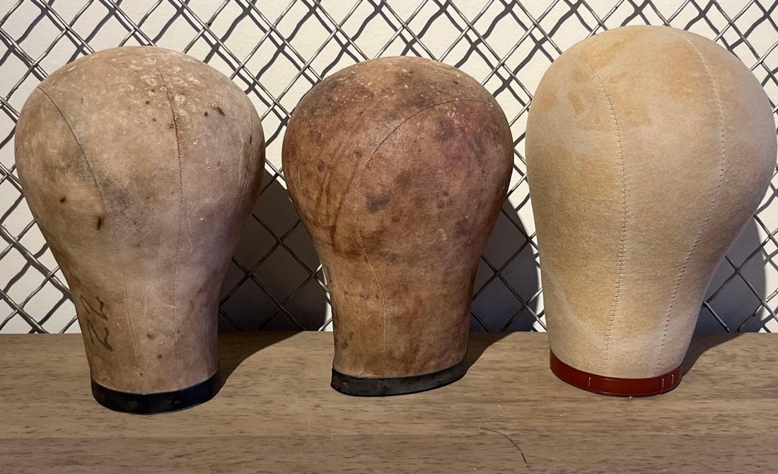 Three Canvas Millinery & Wig Blocks: This lot features three professional-grade head forms utilized for wig styling and hat construction, dating to the mid-to-late 20th century. Each block is constructed from multiple panels of heavy-dut