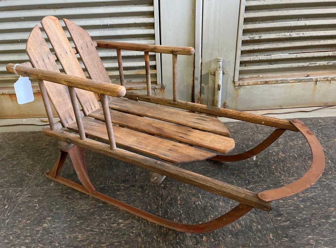 Child's Cutter Style Wood Sled w/ Iron: This is an child's cutter style sit-in sled constructed from solid wood slats and turned spindles mounted on iron runners. The sled features a three-slat backrest in a rustic Adirondack design and a t