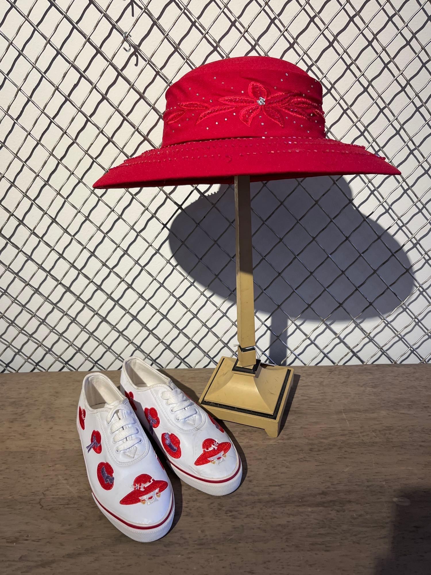 Sebastiano Red Hat Society Accessories: A Chinese-made collection of accessories themed for the Red Hat Society, consisting of a wide-brimmed hat, a pair of embroidered sneakers, and a pedestal stand. The red polyester hat features a wide b