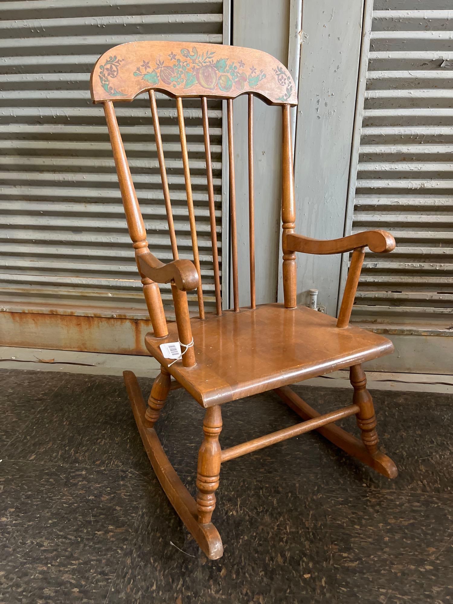 Oak Hill Stenciled Spindle-Back Rocker: An American mid-century spindle-back rocking chair with arms, manufactured by Oak Hill in Fitchburg, Massachusetts. The chair is constructed from a honey-colored hardwood and features a Windsor-style 