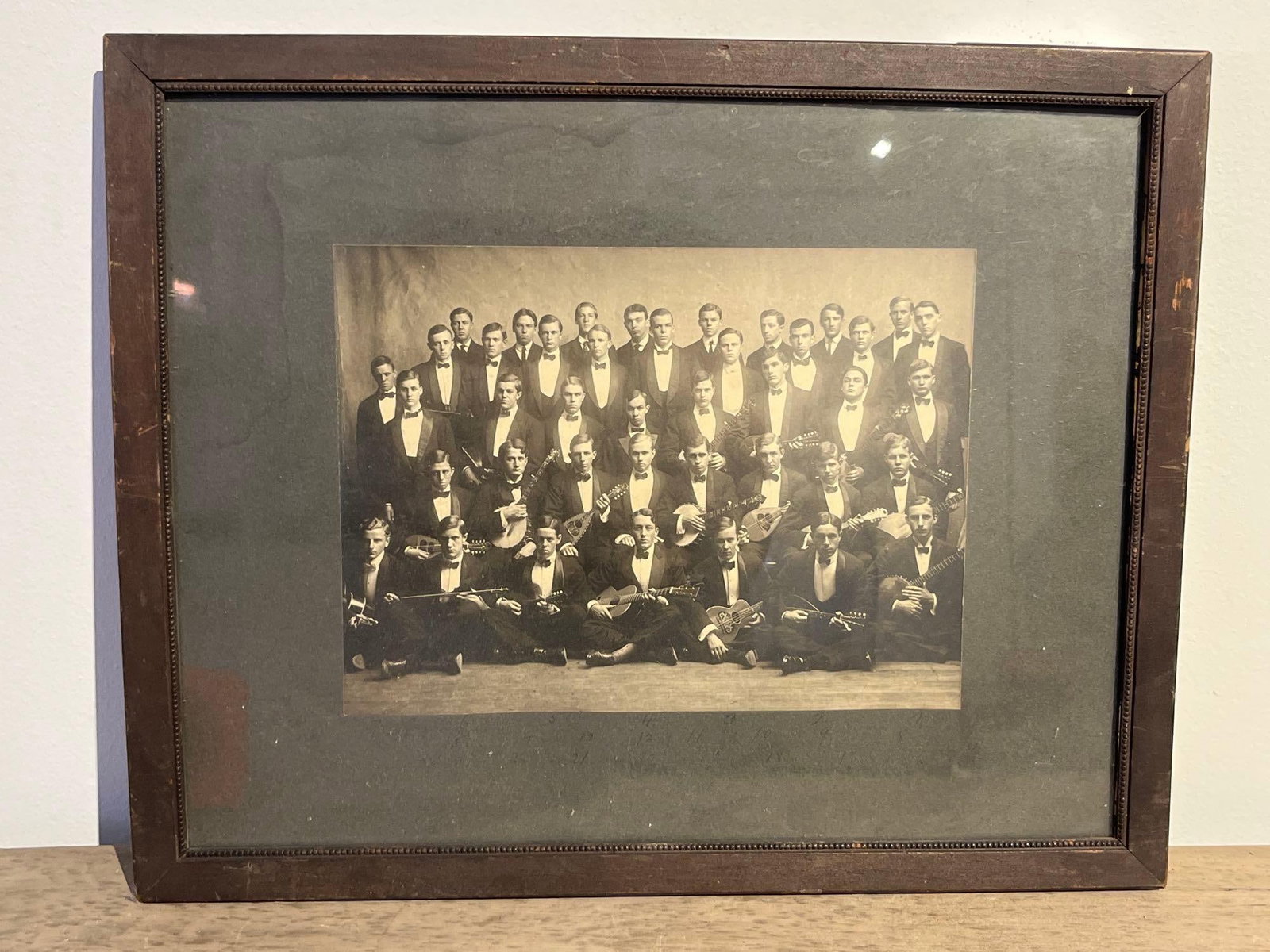 Mandolin & Guitar Club Group Portrait: This framed silver gelatin group portrait, dating to the early 20th century (circa 1900?1915), depicts a large all-male musical ensemble consisting of approximately forty individuals. The subjects are