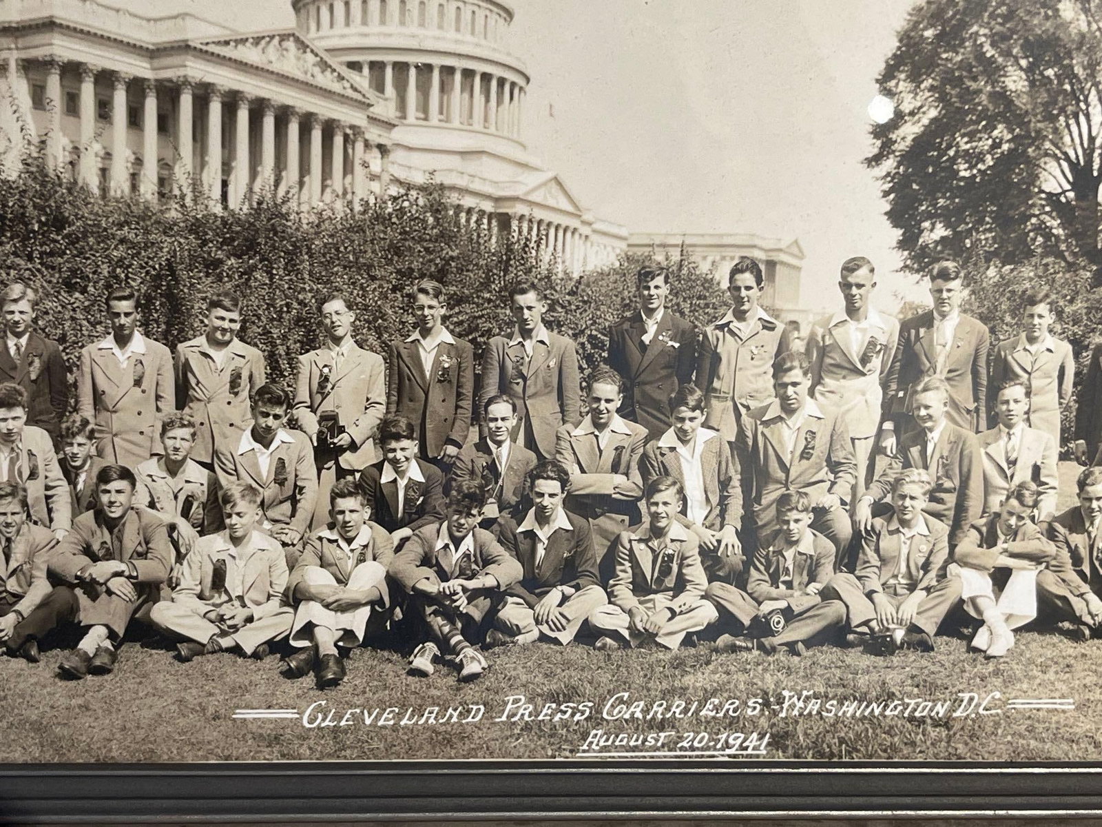 Washington Photo Co, Cleveland Press 41: A silver gelatin panoramic print depicting a group portrait of approximately fifty young men, identified as carriers for the Cleveland Press newspaper. The subjects are posed on a lawn with the
