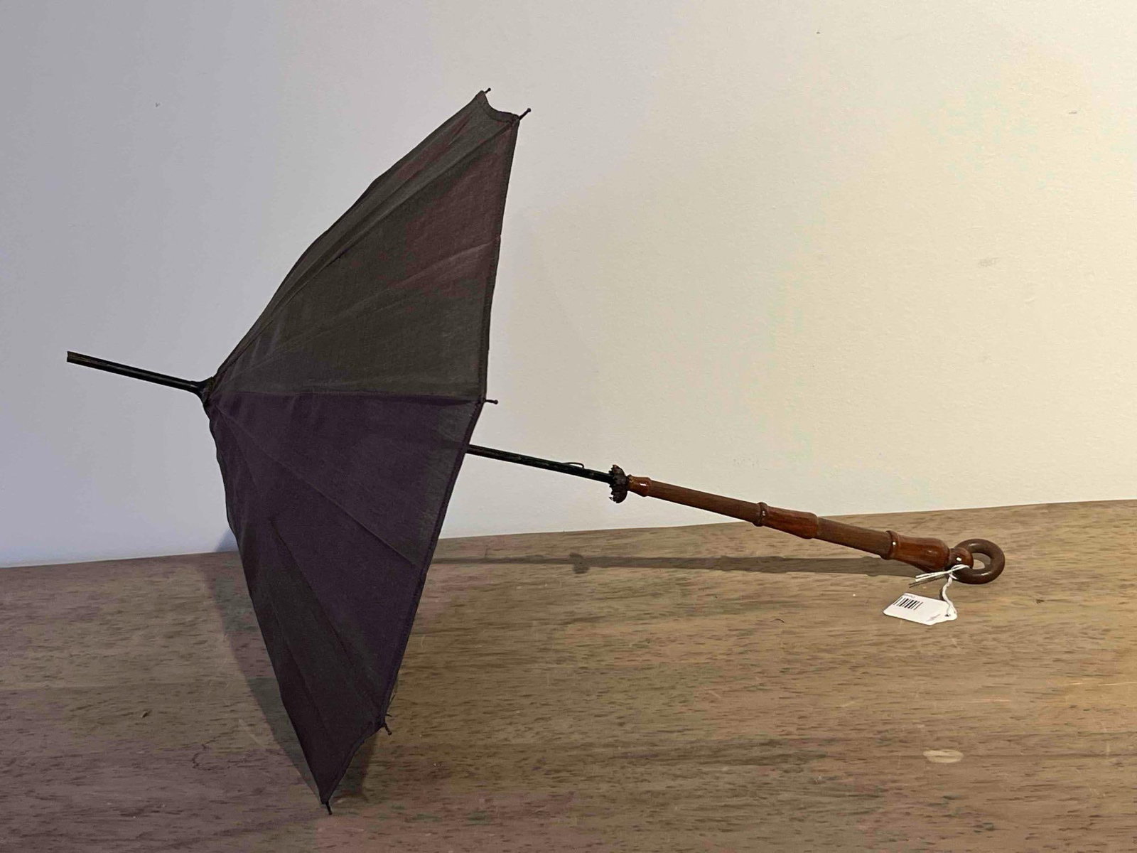 Wood & Fabric Parasol w/ Ring Finial: This parasol is constructed with a decorative turned wood handle and a dark fabric canopy. The handle is composed of dark-stained wood featuring a series of ring-turned accents and a matching circular